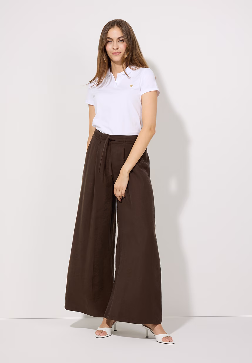 weißes Poloshirt und braune Hose