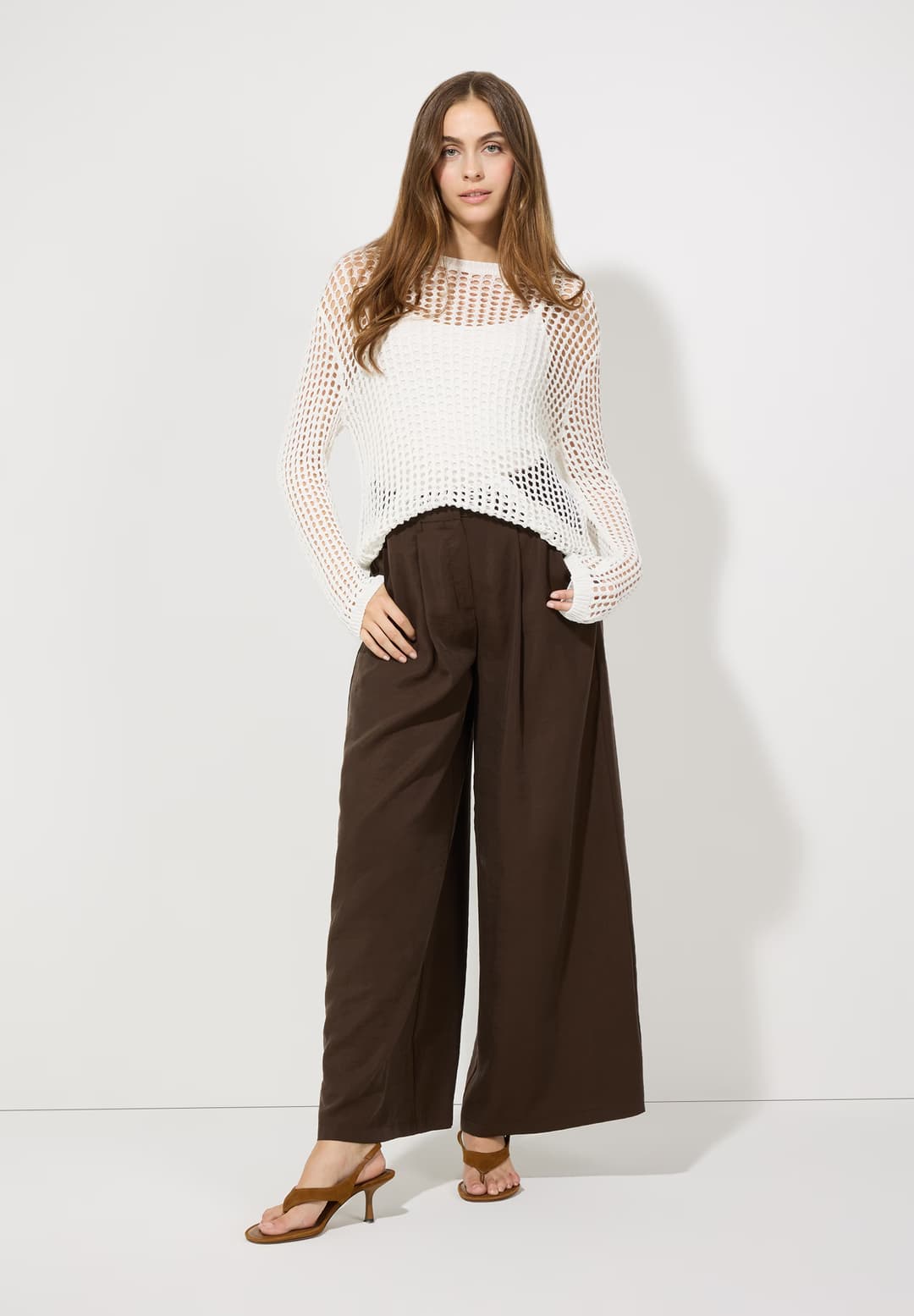 weißer Pullover und braune Hose