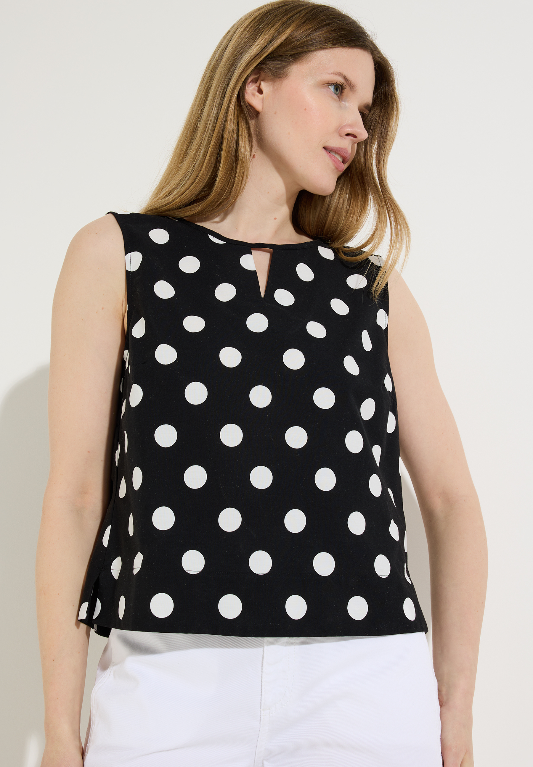 Ärmellose MORE & MORE Bluse mit weißem Punktmuster und Taillenband.