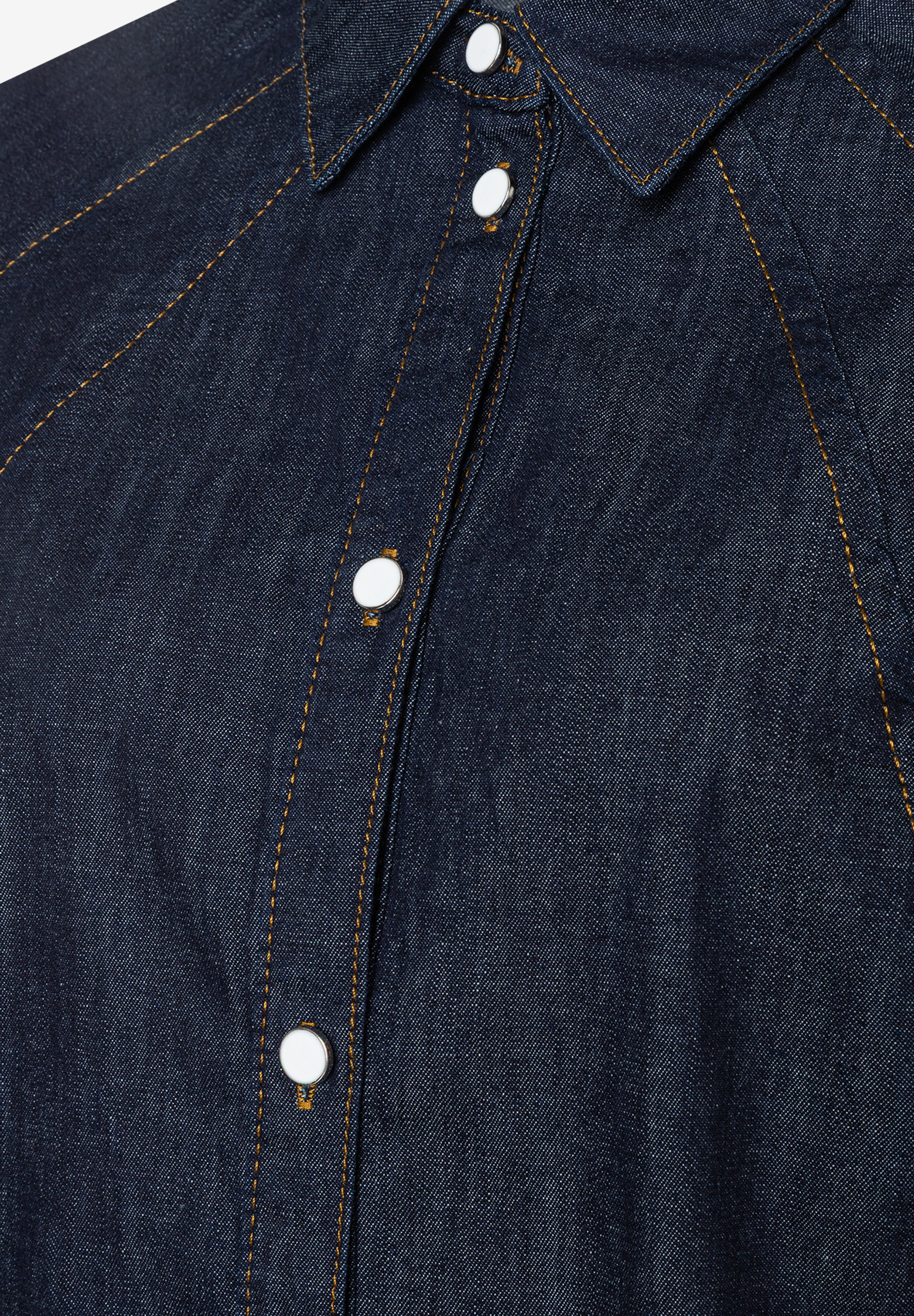 Nahaufnahme einer dunkelblauen MORE & MORE Bluse mit weißen Knöpfen und gelben Ziernähten. Nahaufnahme einer dunkelblauen MORE & MORE Bluse mit weißen Knöpfen und gelben Ziernähten.