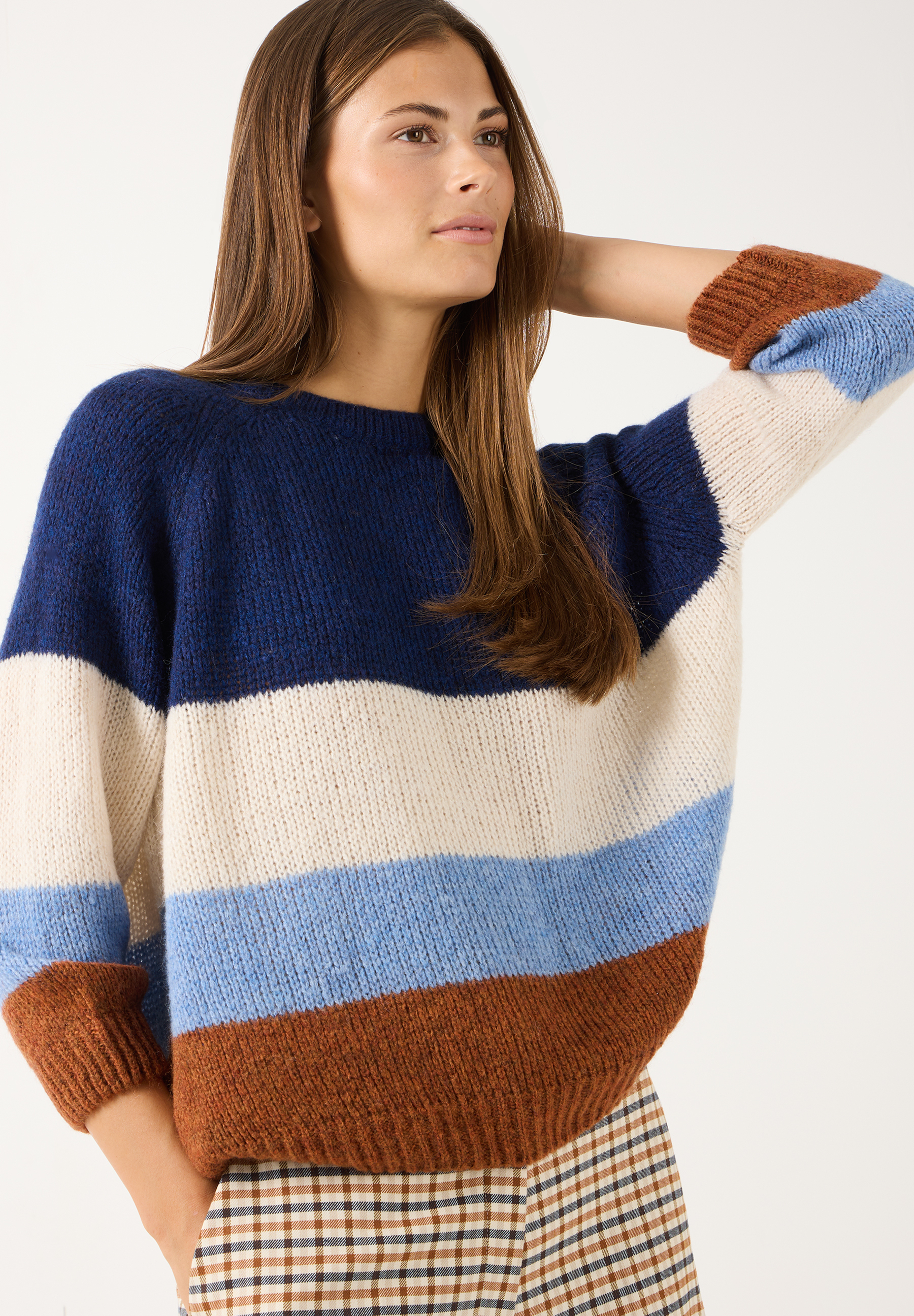 MORE & MORE Pullover: Eine Frau trägt einen mehrfarbigen Pullover mit breiten Querstreifen in Dunkelblau, Weiß, Hellblau und Braun. MORE & MORE Pullover: Eine Frau trägt einen mehrfarbigen Pullover mit breiten Querstreifen in Dunkelblau, Weiß, Hellblau und Braun.