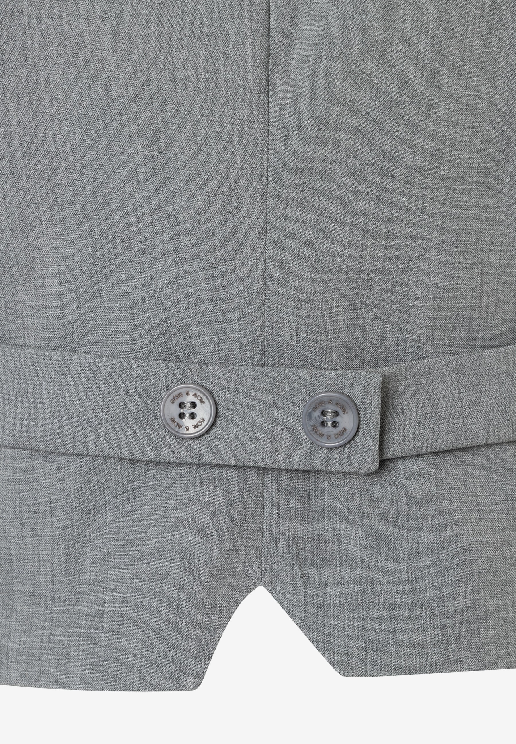 Nahaufnahme eines grauen MORE & MORE Blazers mit zwei Knöpfen am Rücken. Nahaufnahme eines grauen MORE & MORE Blazers mit zwei Knöpfen am Rücken.