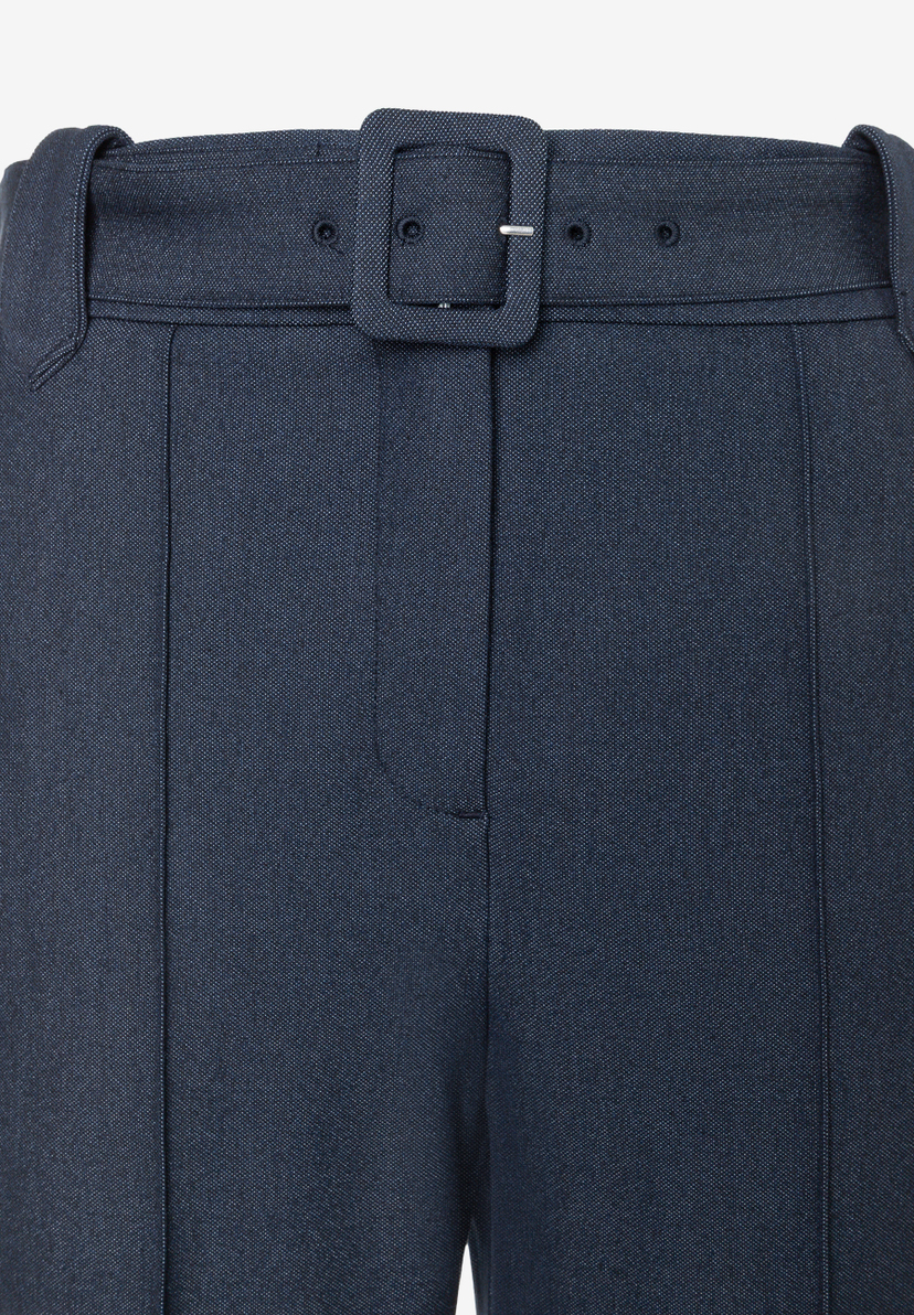 MORE & MORE Jeans: eine detaillierte Nahaufnahme des Oberteils einer dunklen Jeans mit einem passenden Gürtel und rechteckiger Schnalle.