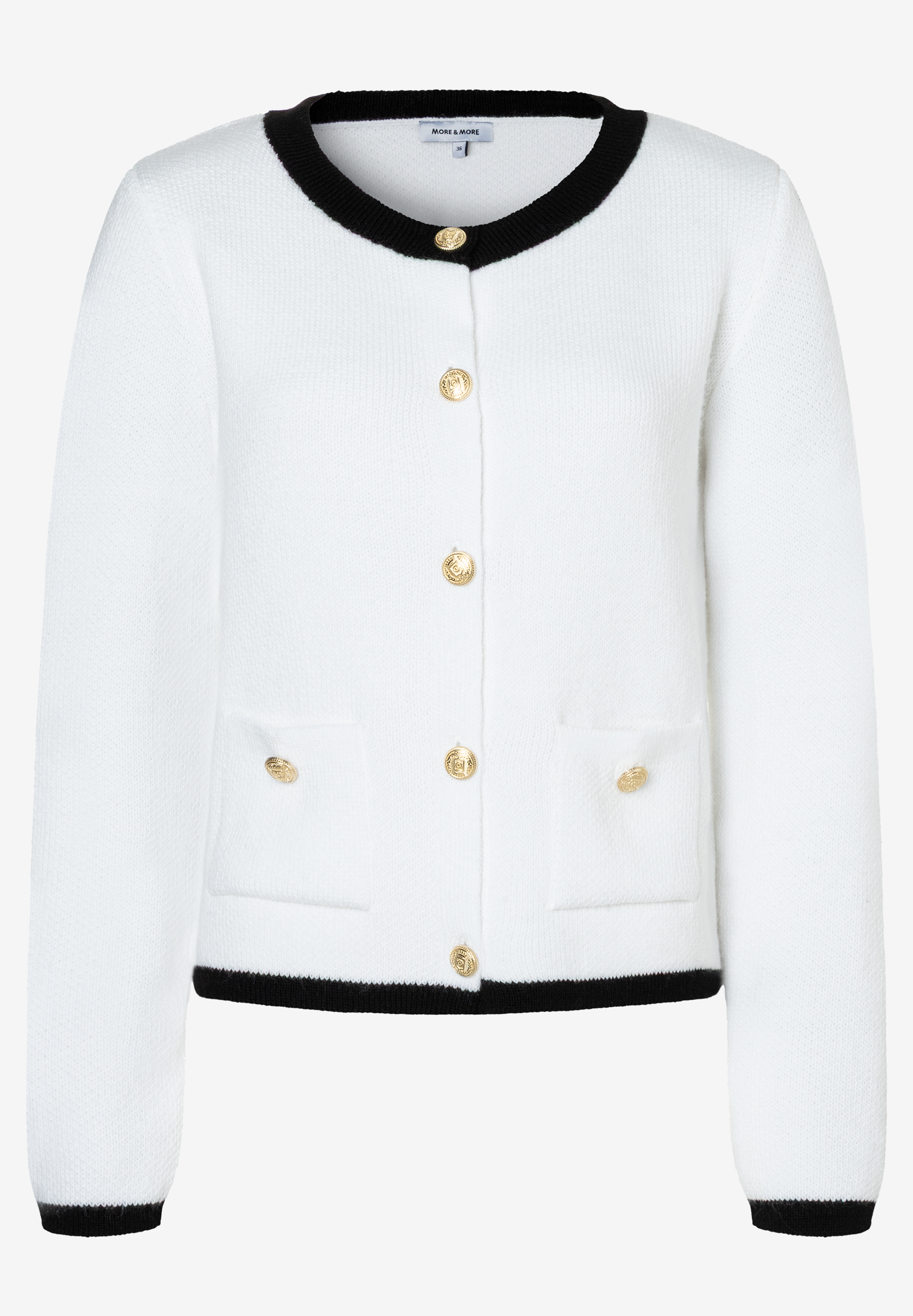 Eine weiße Strickjacke von MORE & MORE mit goldenen Knöpfen und schwarzen Abschlüssen. Eine weiße Strickjacke von MORE & MORE mit goldenen Knöpfen und schwarzen Abschlüssen.