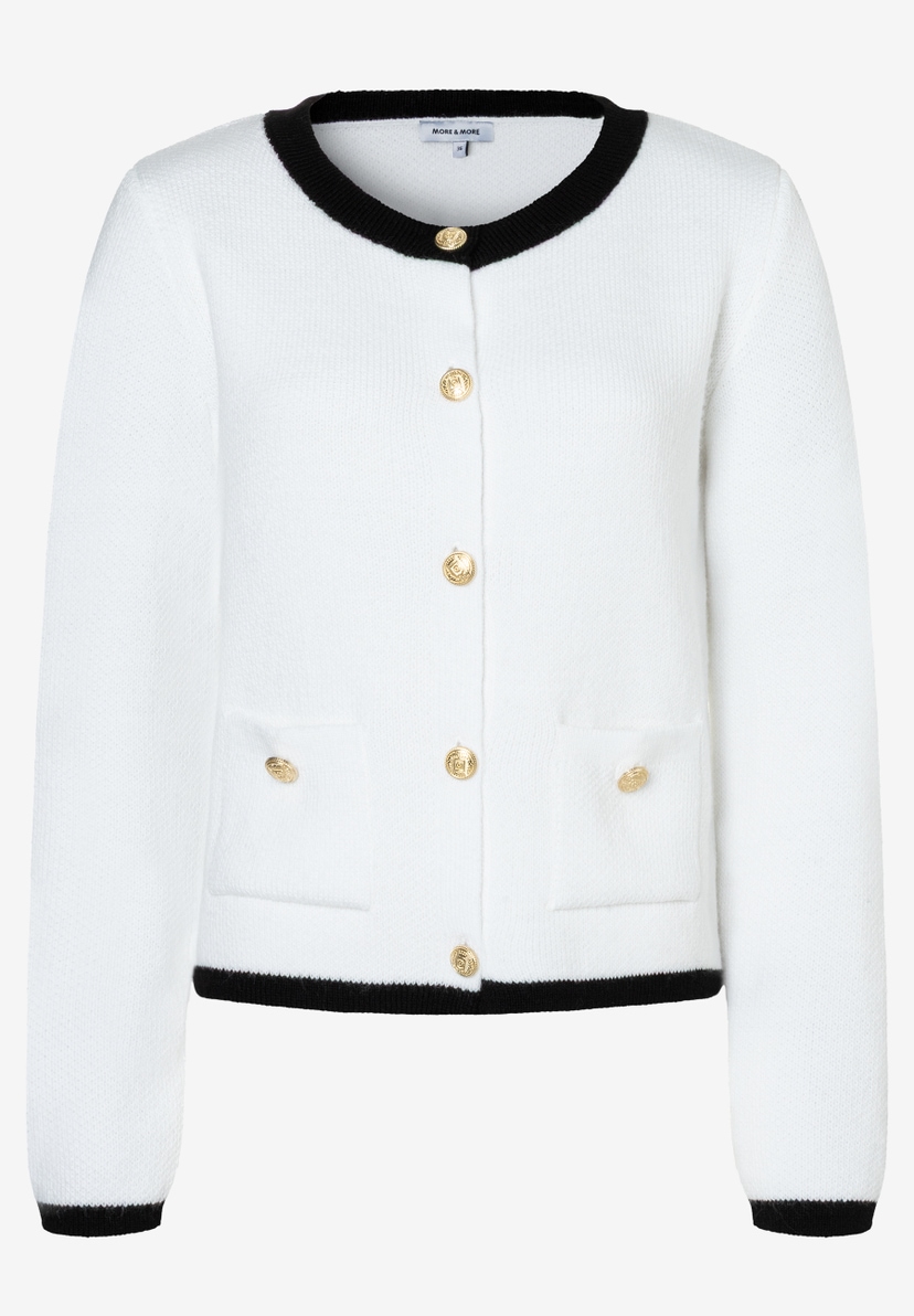 Eine weiße Strickjacke von MORE & MORE mit goldenen Knöpfen und schwarzen Abschlüssen. Eine weiße Strickjacke von MORE & MORE mit goldenen Knöpfen und schwarzen Abschlüssen.