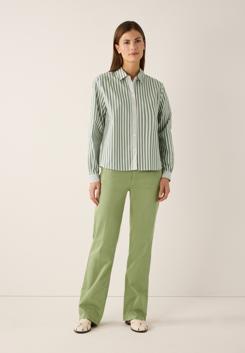Eine Frau trägt eine gestreifte MORE & MORE-Bluse und eine grüne Hose. Eine Frau trägt eine gestreifte MORE & MORE-Bluse und eine grüne Hose.