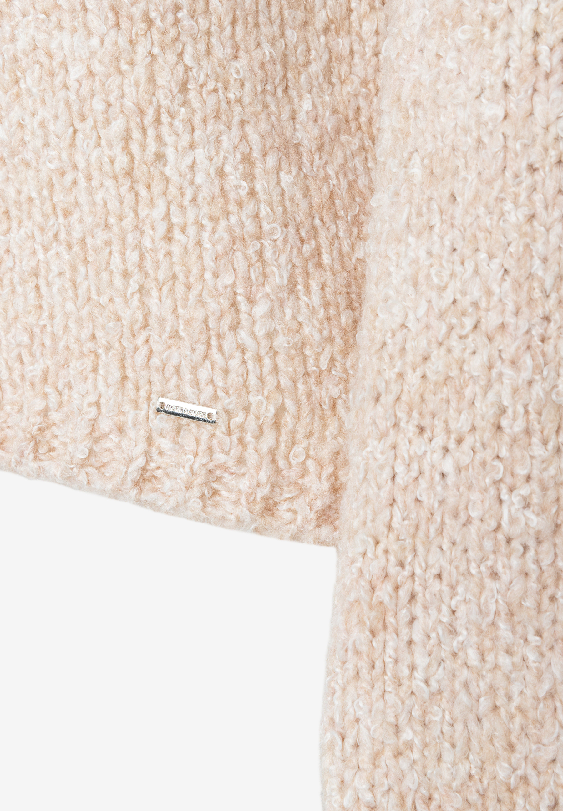 MORE & MORE Pullover & Strickware: Nahaufnahme eines beigen, locker gestrickten Stoffes mit feinen Schlaufen. Links eine kleine Metallschnalle mit der Aufschrift „MORE & MORE“.