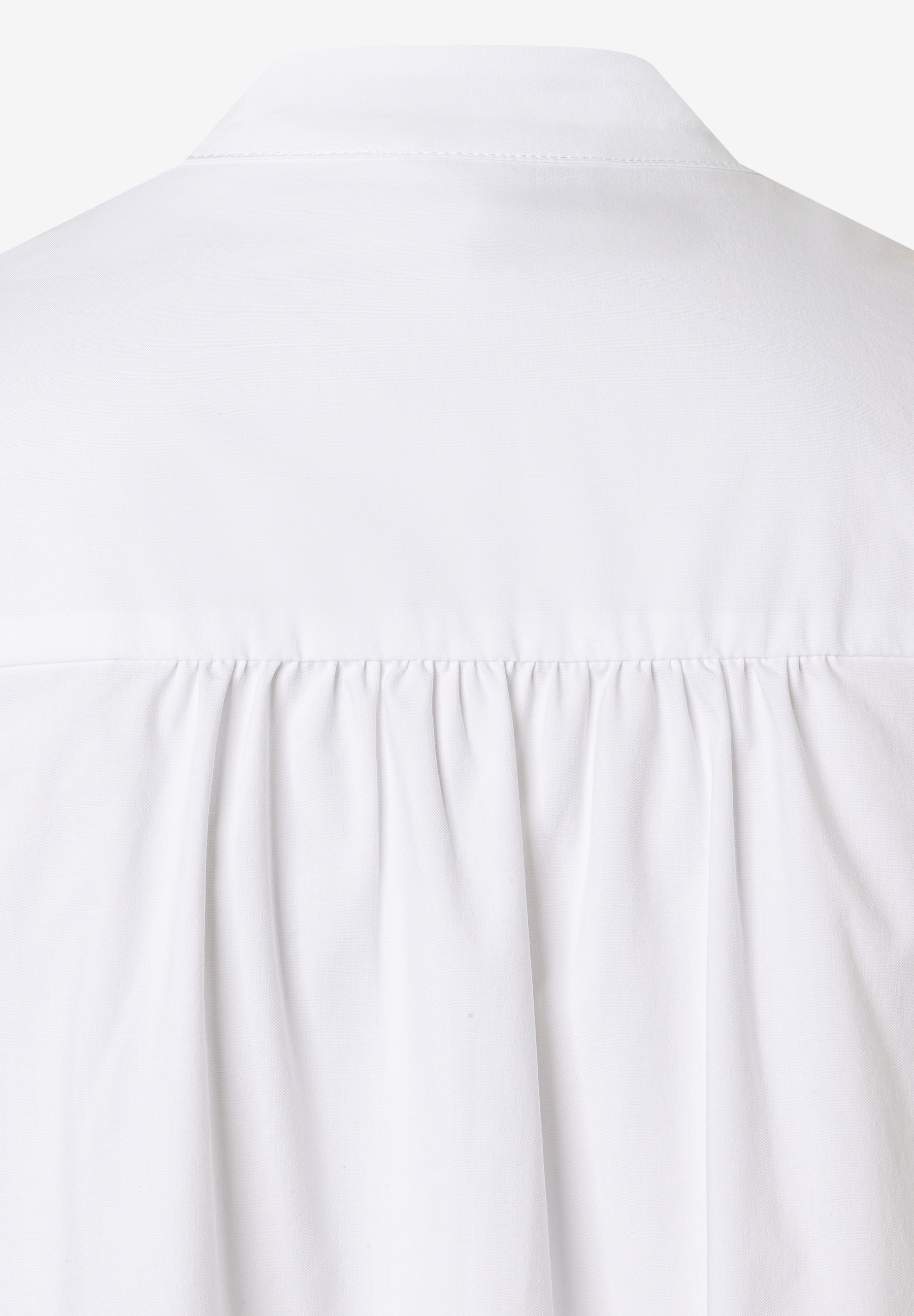 Detailansicht einer weißen MORE & MORE Bluse mit Falten unterhalb des Kragens. Detailansicht einer weißen MORE & MORE Bluse mit Falten unterhalb des Kragens.
