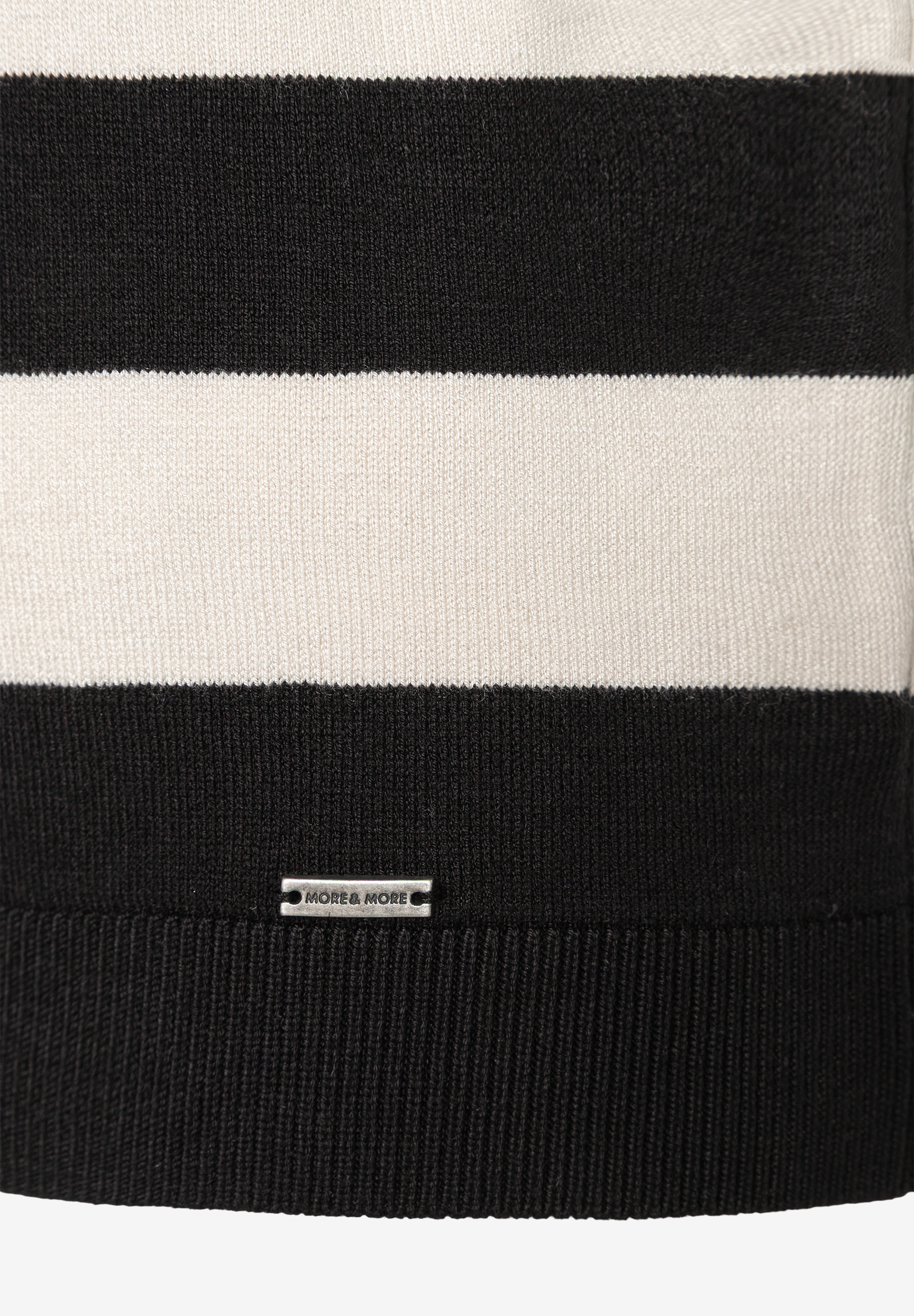 Nahaufnahme eines schwarz-weiß gestreiften MORE & MORE Feinstrick-Pullovers. Nahaufnahme eines schwarz-weiß gestreiften MORE & MORE Feinstrick-Pullovers.