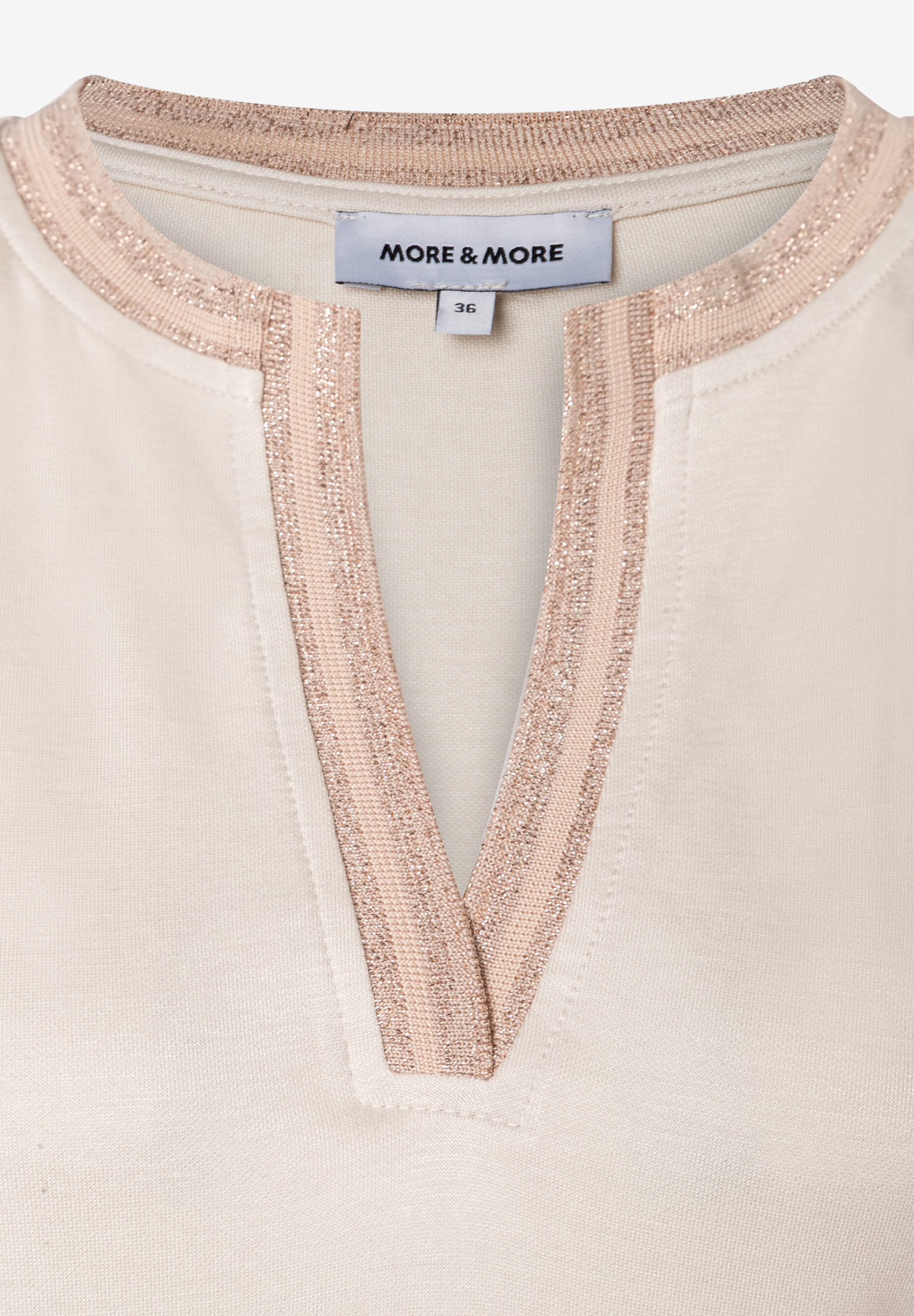 Detailansicht eines MORE & MORE Oberteils mit Jersey-Struktur und V-Ausschnitt mit Glitzer-Details. Detailansicht eines MORE & MORE Oberteils mit Jersey-Struktur und V-Ausschnitt mit Glitzer-Details.