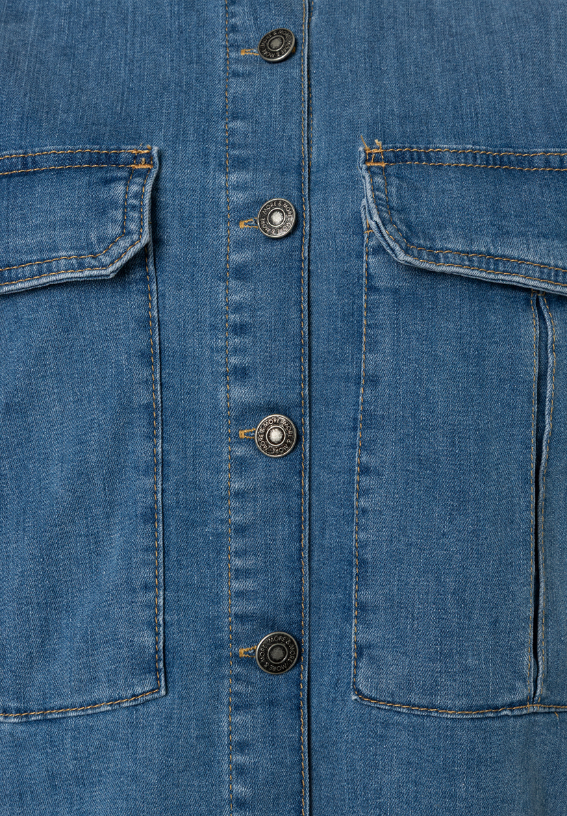 Nahaufnahme einer MORE & MORE Jeansjacke mit Taschen und Knöpfen. Nahaufnahme einer MORE & MORE Jeansjacke mit Taschen und Knöpfen.