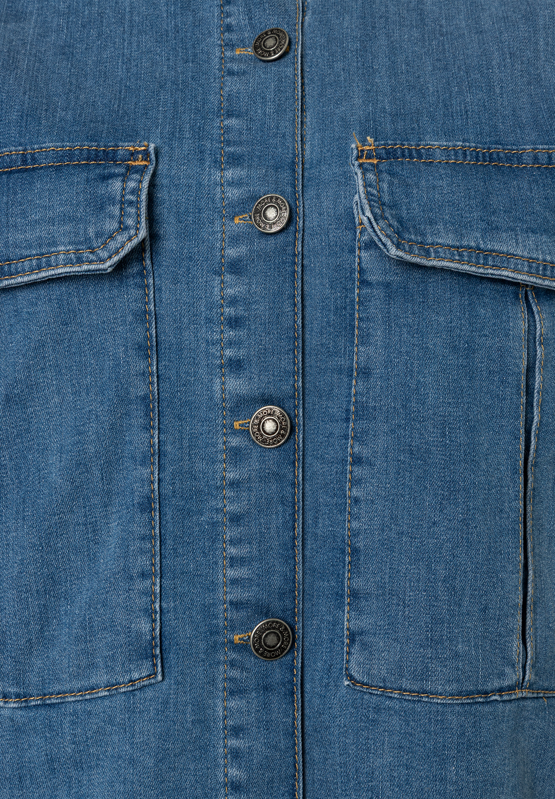 Nahaufnahme einer MORE & MORE Jeansjacke mit Taschen und Knöpfen. Nahaufnahme einer MORE & MORE Jeansjacke mit Taschen und Knöpfen.