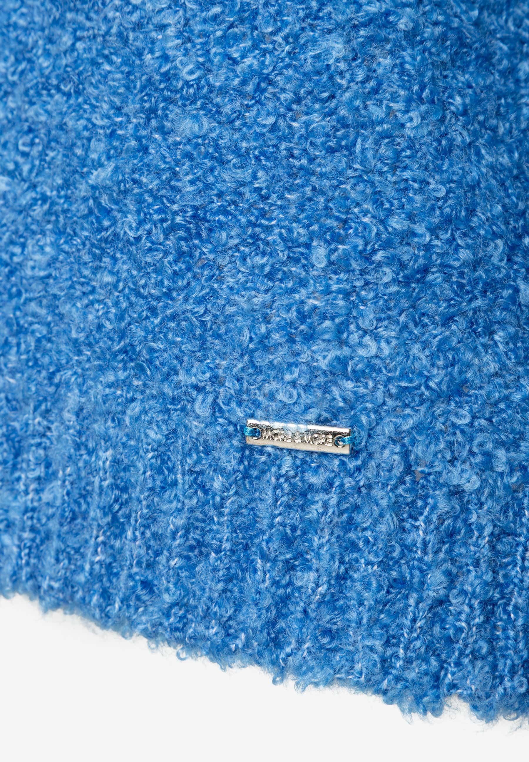 Nahaufnahme eines blauen MORE & MORE Bouclé-Oberteils mit Logo-Schild, das einen angenehmen Tragekomfort verspricht. Nahaufnahme eines blauen MORE & MORE Bouclé-Oberteils mit Logo-Schild, das einen angenehmen Tragekomfort verspricht.
