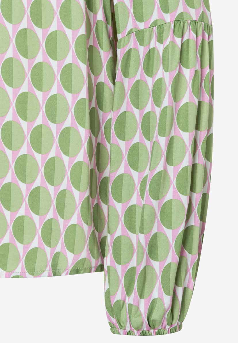 Detailaufnahme einer MORE & MORE Bluse mit grün-rosa Muster und fließender Viskose. Detailaufnahme einer MORE & MORE Bluse mit grün-rosa Muster und fließender Viskose.
