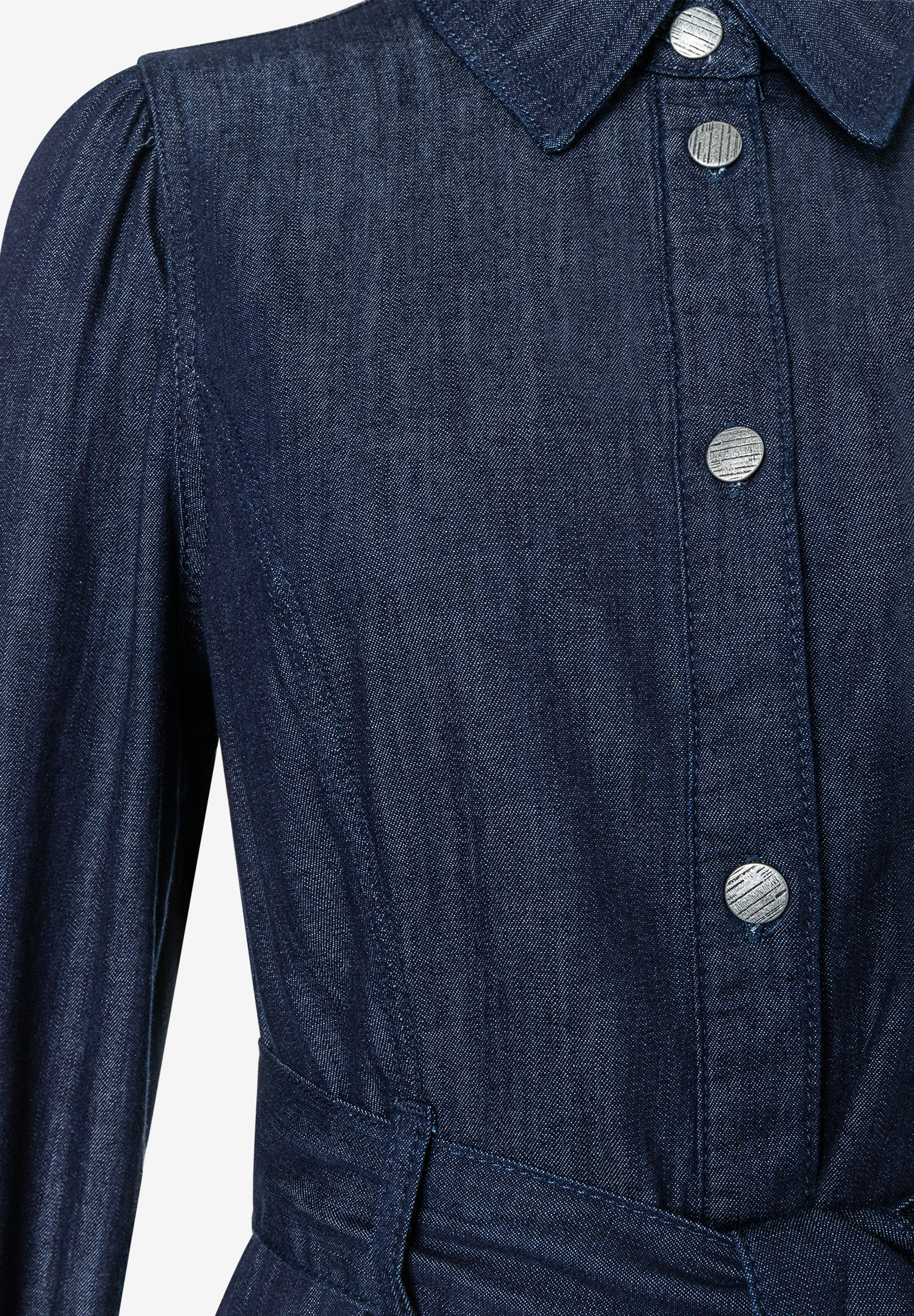 Nahaufnahme eines MORE & MORE Oberteils aus Denim mit Knöpfen und langen Ärmeln. Nahaufnahme eines MORE & MORE Oberteils aus Denim mit Knöpfen und langen Ärmeln.