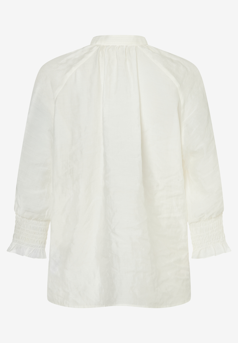 Eine MORE & MORE Bluse in Weiß mit langen Ärmeln und Rüschen an den Bündchen. Eine MORE & MORE Bluse in Weiß mit langen Ärmeln und Rüschen an den Bündchen.