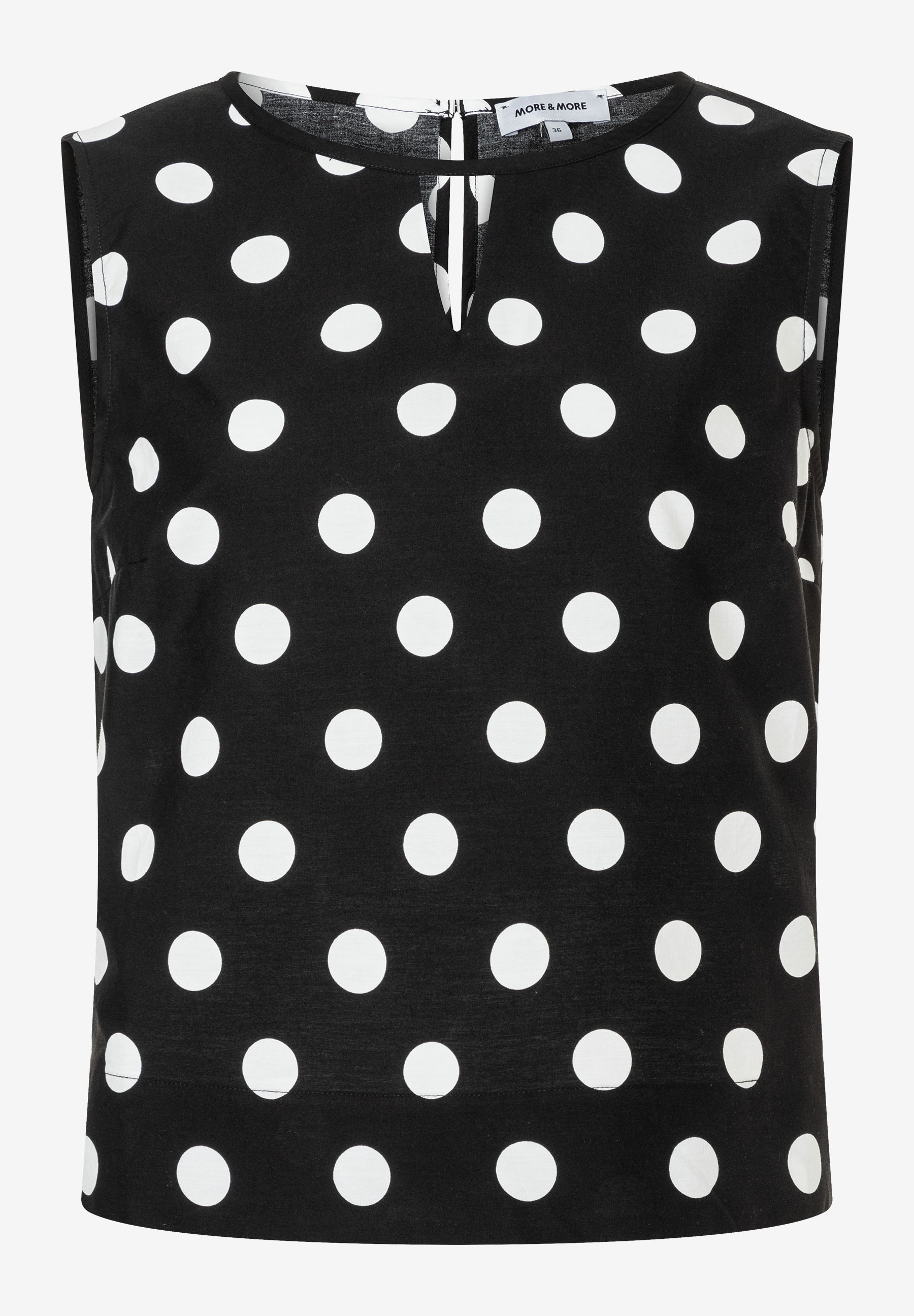 Eine ärmellose MORE & MORE Bluse mit weißen Punkten auf schwarzem Stoff. Eine ärmellose MORE & MORE Bluse mit weißen Punkten auf schwarzem Stoff.