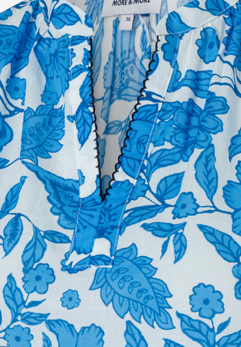MORE & MORE Bluse: Weißes Oberteil mit großen, blauen Paisley-Mustern und Blumen. V-Ausschnitt mit Wellenrand. MORE & MORE Bluse: Weißes Oberteil mit großen, blauen Paisley-Mustern und Blumen. V-Ausschnitt mit Wellenrand.