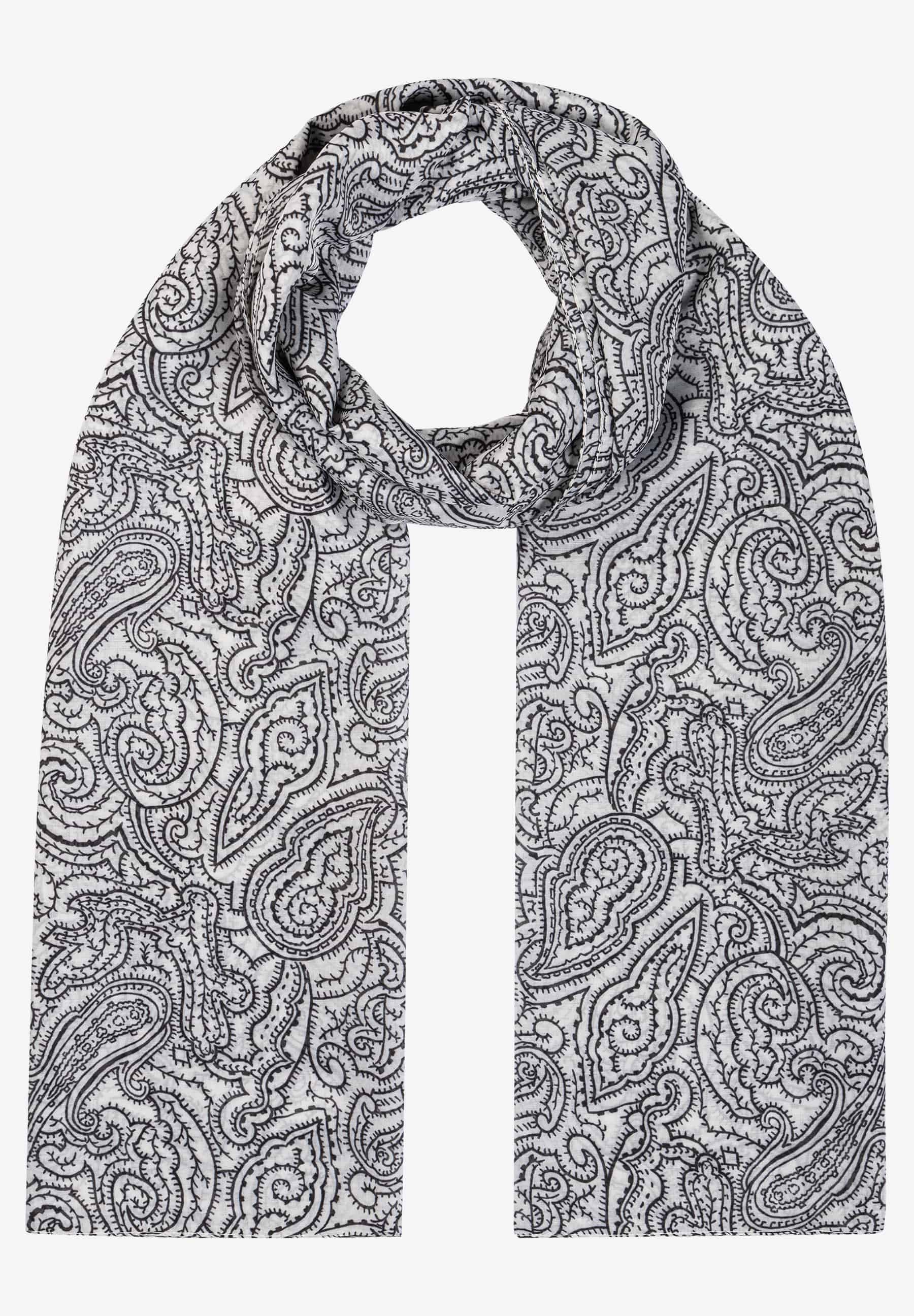 Ein MORE & MORE-Accessoire: Ein weißer Schal mit einem schwarzen Paisley-Muster ist um den Hals drapiert.
