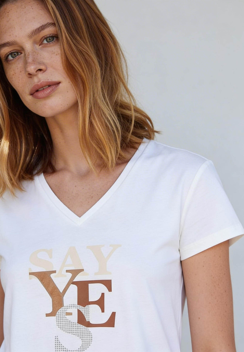 AI generated - Porträt einer Frau mit Sommersprossen, die ein weißes T-Shirt von MORE & MORE mit dem Aufdruck 'Say Yes' trägt. AI generated - Porträt einer Frau mit Sommersprossen, die ein weißes T-Shirt von MORE & MORE mit dem Aufdruck 'Say Yes' trägt.