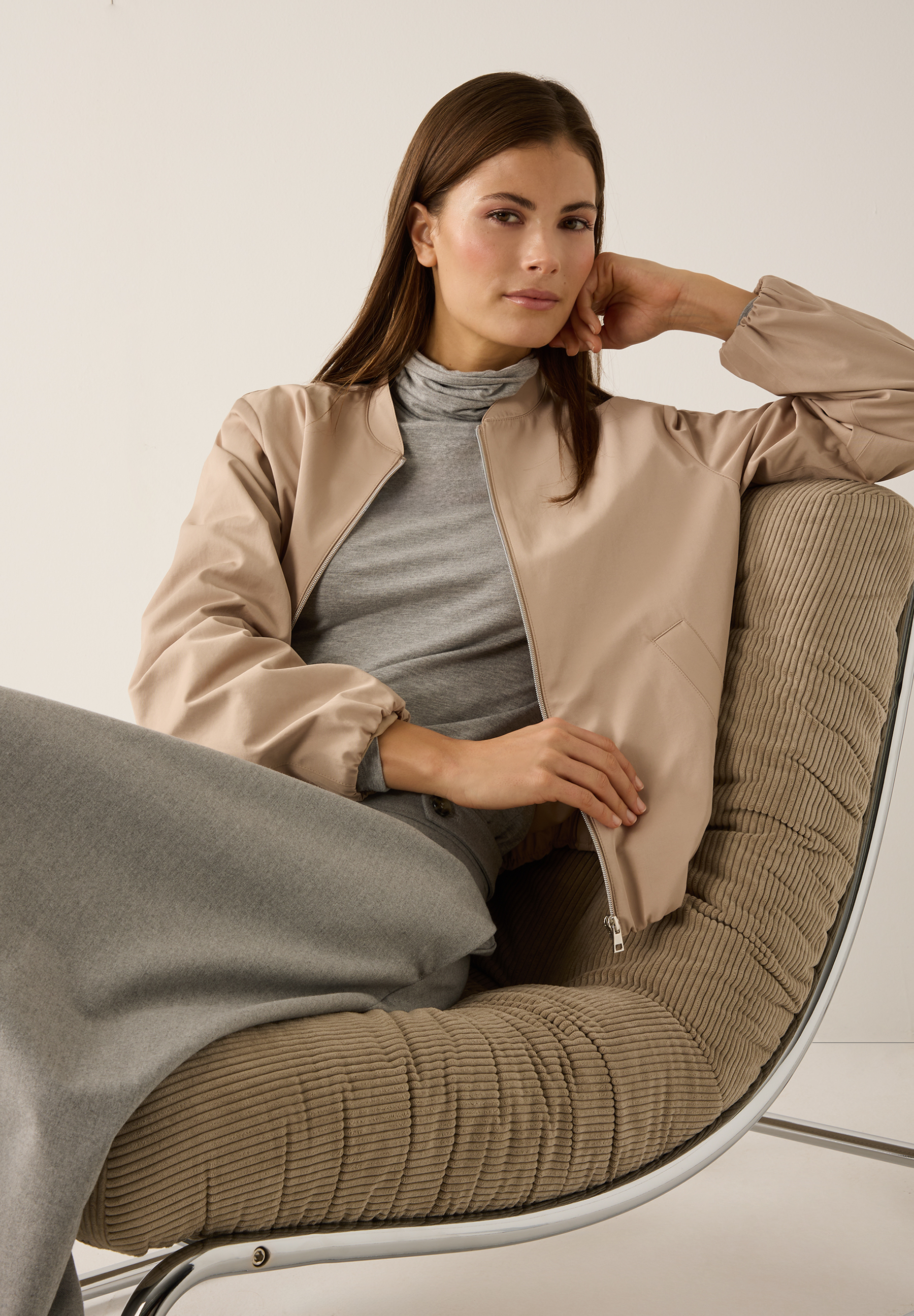 Eine Frau sitzt in einem Stuhl und trägt einen MORE & MORE Blazer aus Webware. Sie lehnt ihren Kopf an ihre Hand. Eine Frau sitzt in einem Stuhl und trägt einen MORE & MORE Blazer aus Webware. Sie lehnt ihren Kopf an ihre Hand.