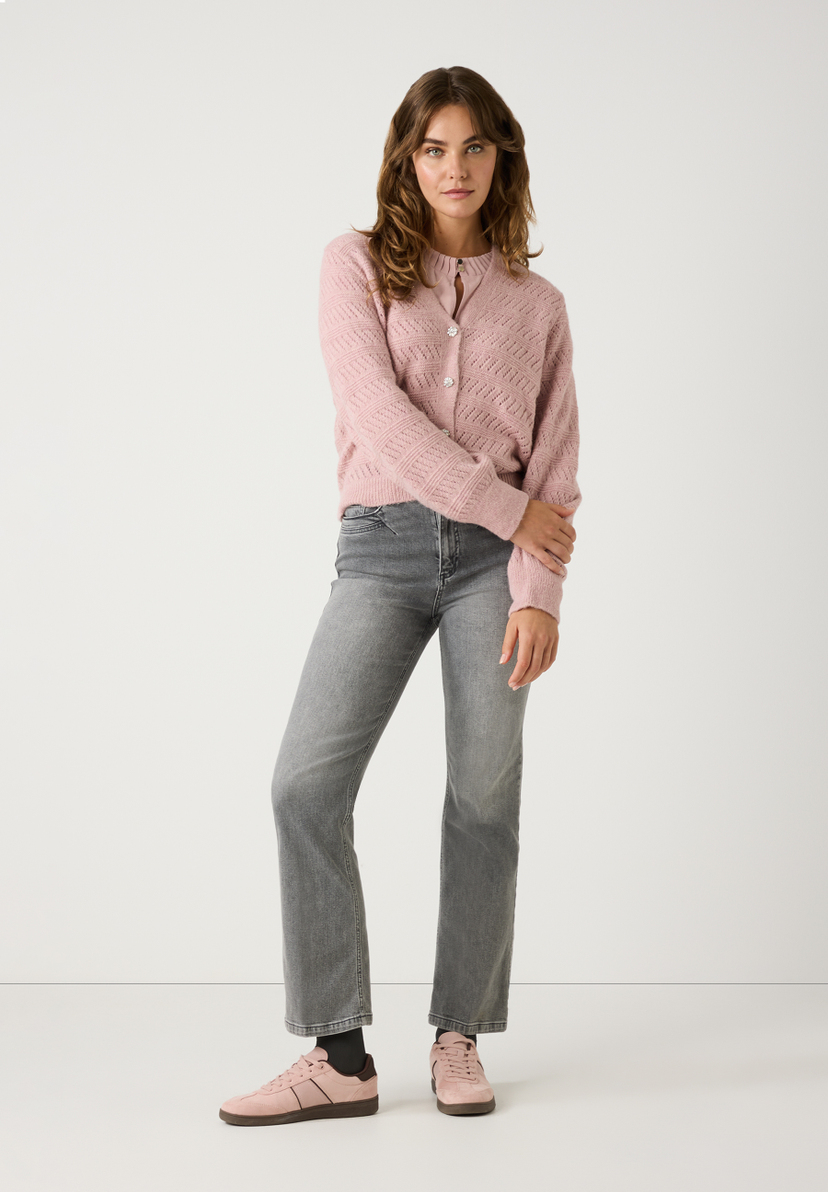 Eine Frau trägt einen MORE & MORE Lochstrick-Cardigan in Altrosa, graue Jeans und rosa Sneakers vor einem weißen Hintergrund. Eine Frau trägt einen MORE & MORE Lochstrick-Cardigan in Altrosa, graue Jeans und rosa Sneakers vor einem weißen Hintergrund.