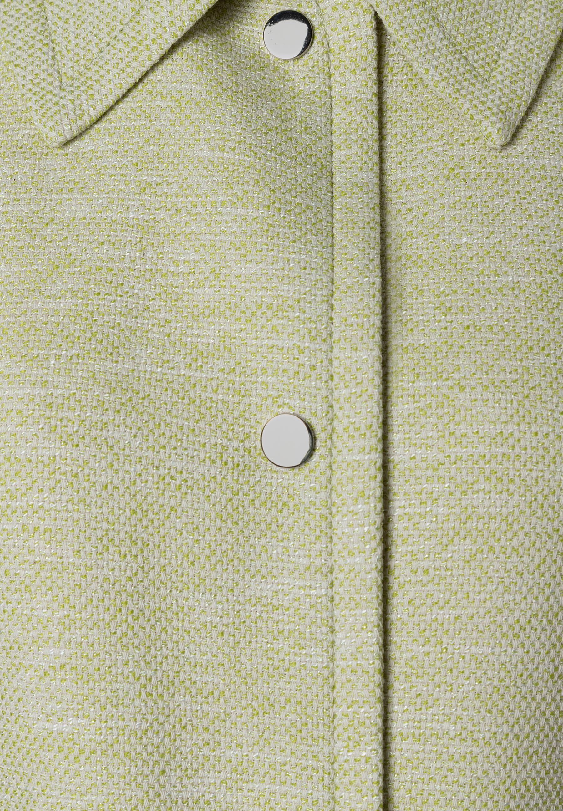 Nahaufnahme eines Bouclé-Blazers von MORE & MORE mit silbernen Knöpfen. Nahaufnahme eines Bouclé-Blazers von MORE & MORE mit silbernen Knöpfen.