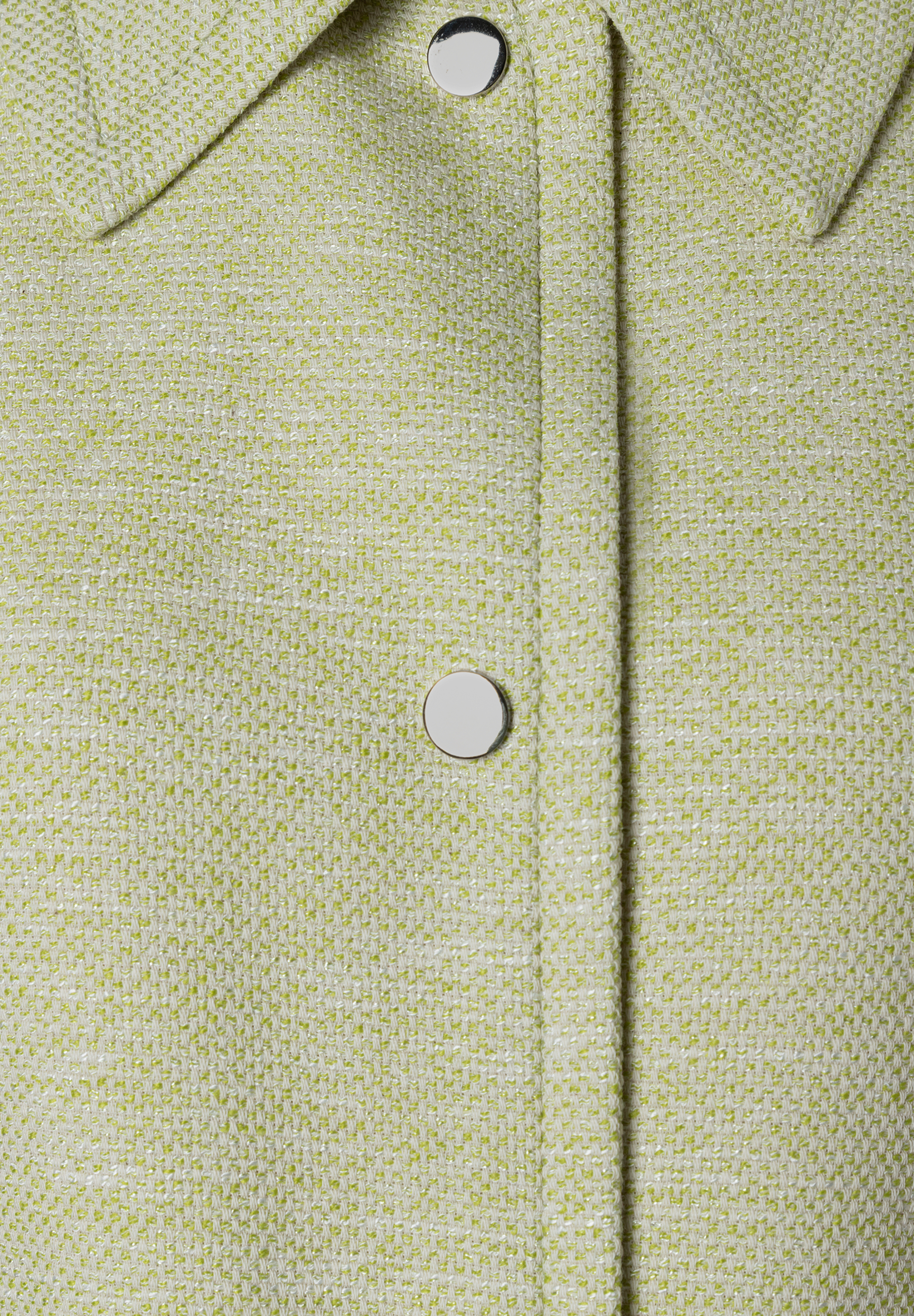 Nahaufnahme eines Bouclé-Blazers von MORE & MORE mit silbernen Knöpfen. Nahaufnahme eines Bouclé-Blazers von MORE & MORE mit silbernen Knöpfen.