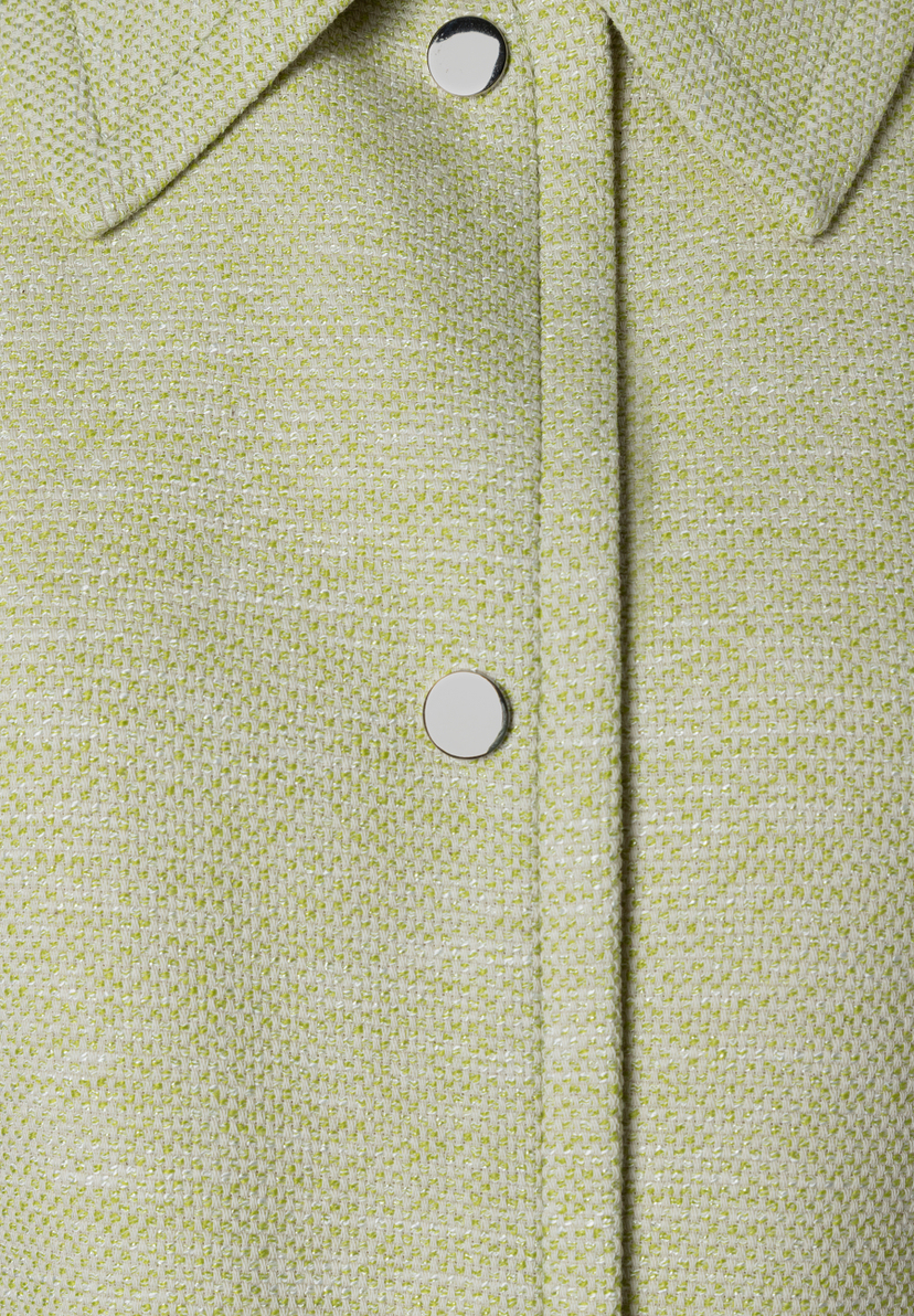 Nahaufnahme eines Bouclé-Blazers von MORE & MORE mit silbernen Knöpfen. Nahaufnahme eines Bouclé-Blazers von MORE & MORE mit silbernen Knöpfen.