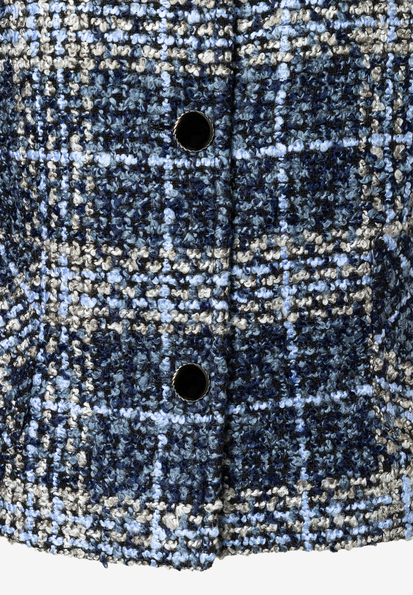 Detailansicht eines MORE & MORE Oberteils aus blauem Bouclé-Material mit zwei Knöpfen. Detailansicht eines MORE & MORE Oberteils aus blauem Bouclé-Material mit zwei Knöpfen.