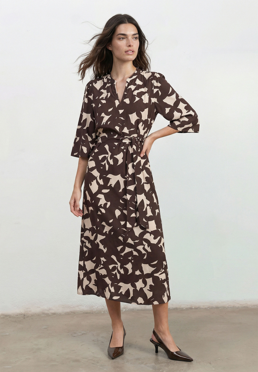 MORE & MORE Kleid: Eine Frau trägt ein braun-beige gemustertes Midikleid mit V-Ausschnitt, 3/4-Ärmeln und Taillengürtel.