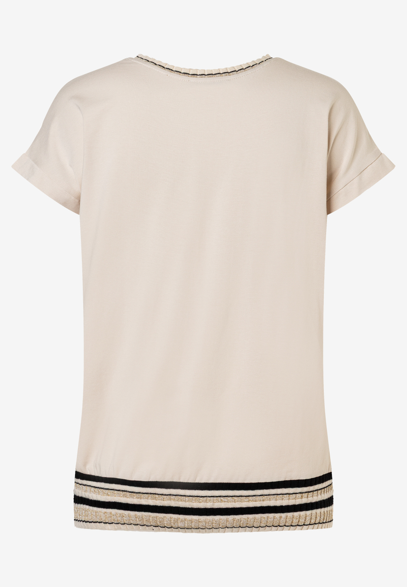 Ein MORE & MORE Jersey-Top in Beige mit dekorativen schwarzen und goldenen Streifen am Halsausschnitt und Saum. Ein MORE & MORE Jersey-Top in Beige mit dekorativen schwarzen und goldenen Streifen am Halsausschnitt und Saum.
