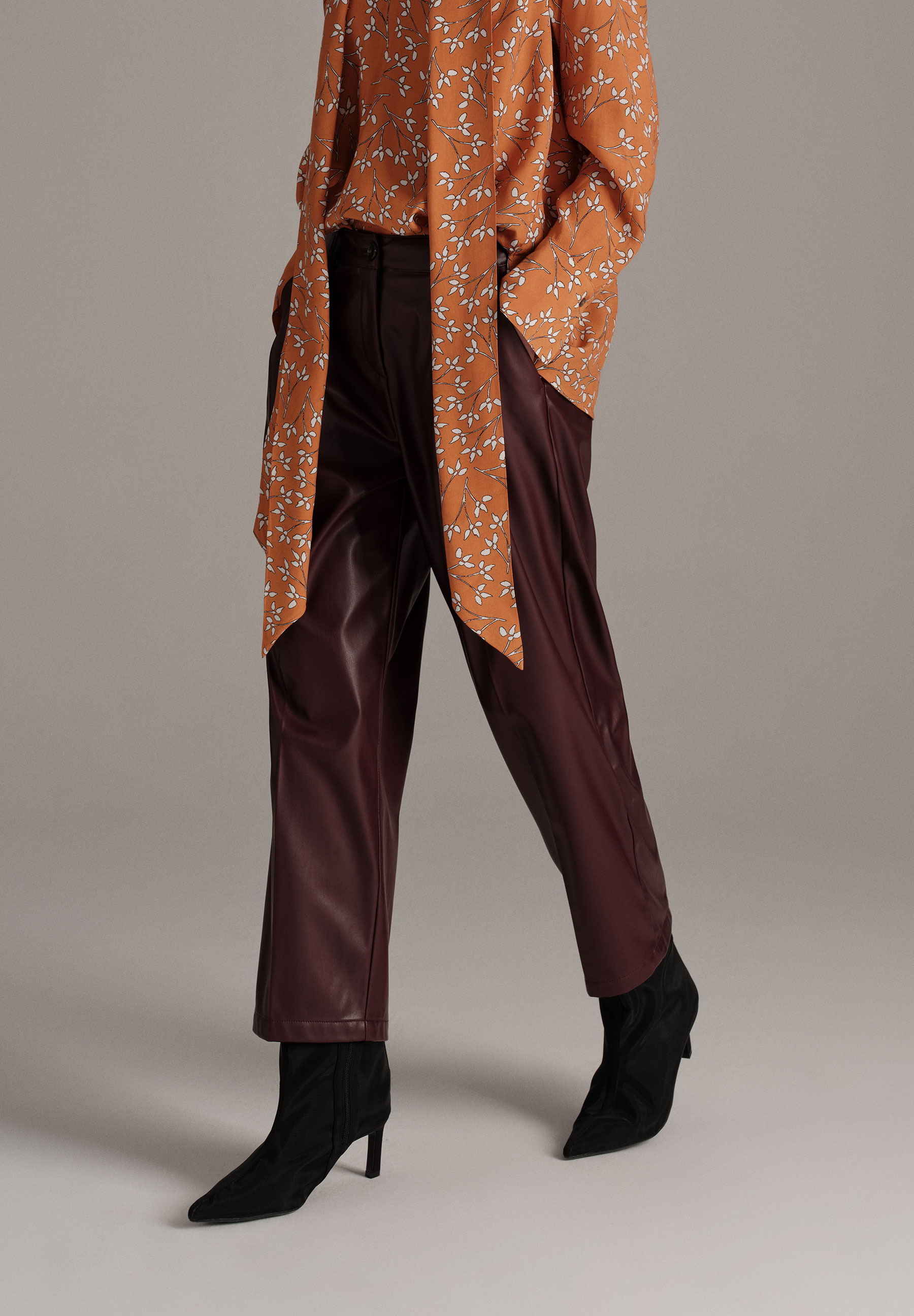 MORE & MORE Hose in Lederoptik mit Bluse und Stiefeletten vor neutralem Hintergrund.