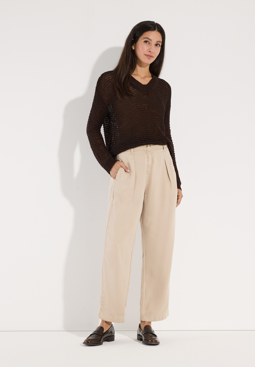 MORE & MORE Pullover: Eine Frau trägt einen braunen Strickpullover mit V-Ausschnitt und beigefarbene Hosen zu Loafers. MORE & MORE Pullover: Eine Frau trägt einen braunen Strickpullover mit V-Ausschnitt und beigefarbene Hosen zu Loafers.