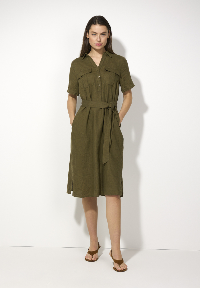 Eine Frau trägt ein olivgrünes MORE & MORE Leinenkleid mit Gürtel und Sandalen vor einem weißen Hintergrund. Eine Frau trägt ein olivgrünes MORE & MORE Leinenkleid mit Gürtel und Sandalen vor einem weißen Hintergrund.