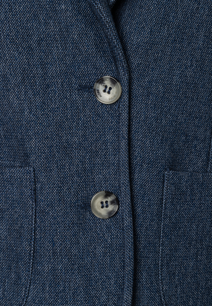 Nahaufnahme eines MORE & MORE Blazers mit Piqué-Struktur und zwei Knöpfen. Nahaufnahme eines MORE & MORE Blazers mit Piqué-Struktur und zwei Knöpfen.