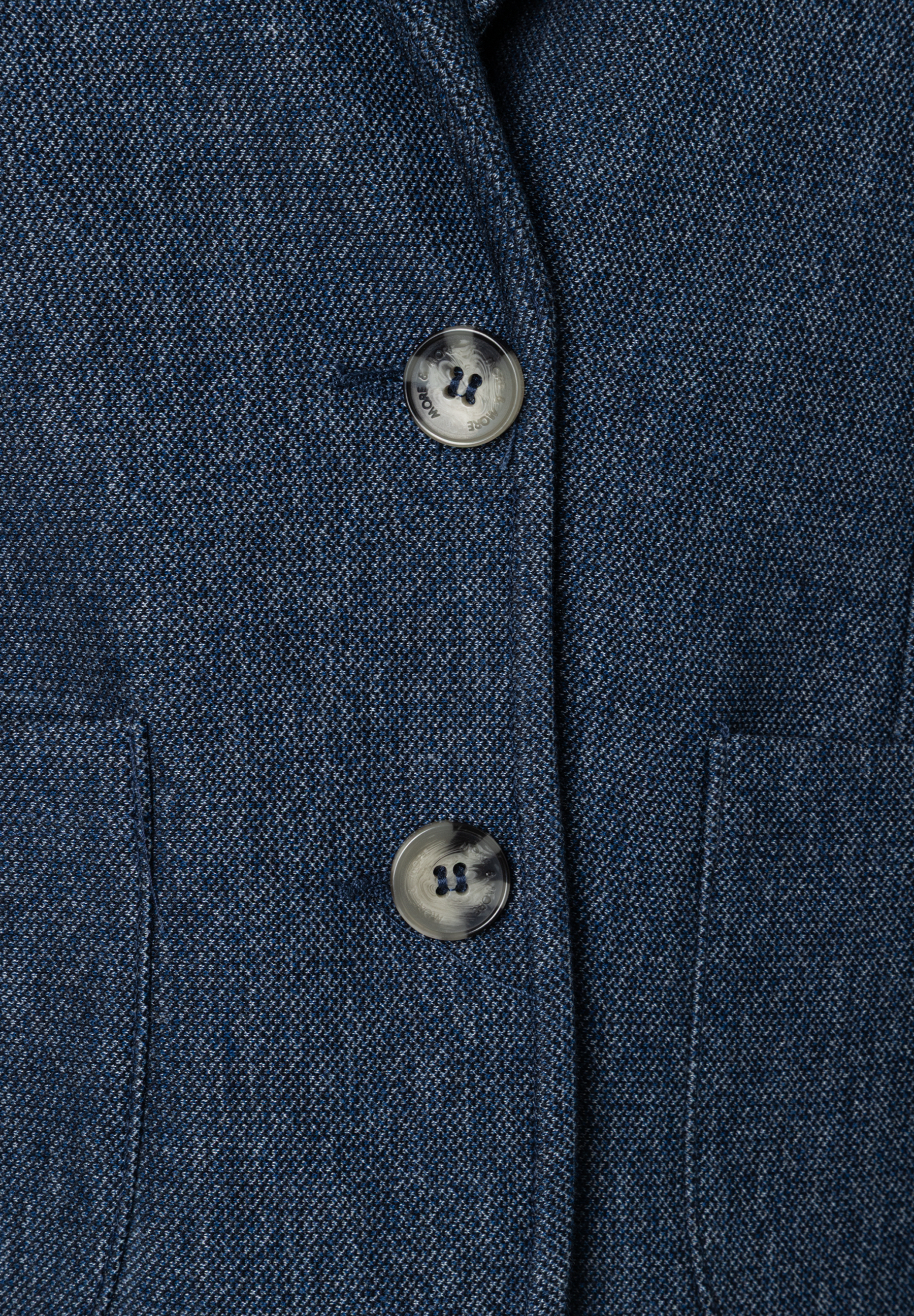 Nahaufnahme eines MORE & MORE Blazers mit Piqué-Struktur und zwei Knöpfen. Nahaufnahme eines MORE & MORE Blazers mit Piqué-Struktur und zwei Knöpfen.