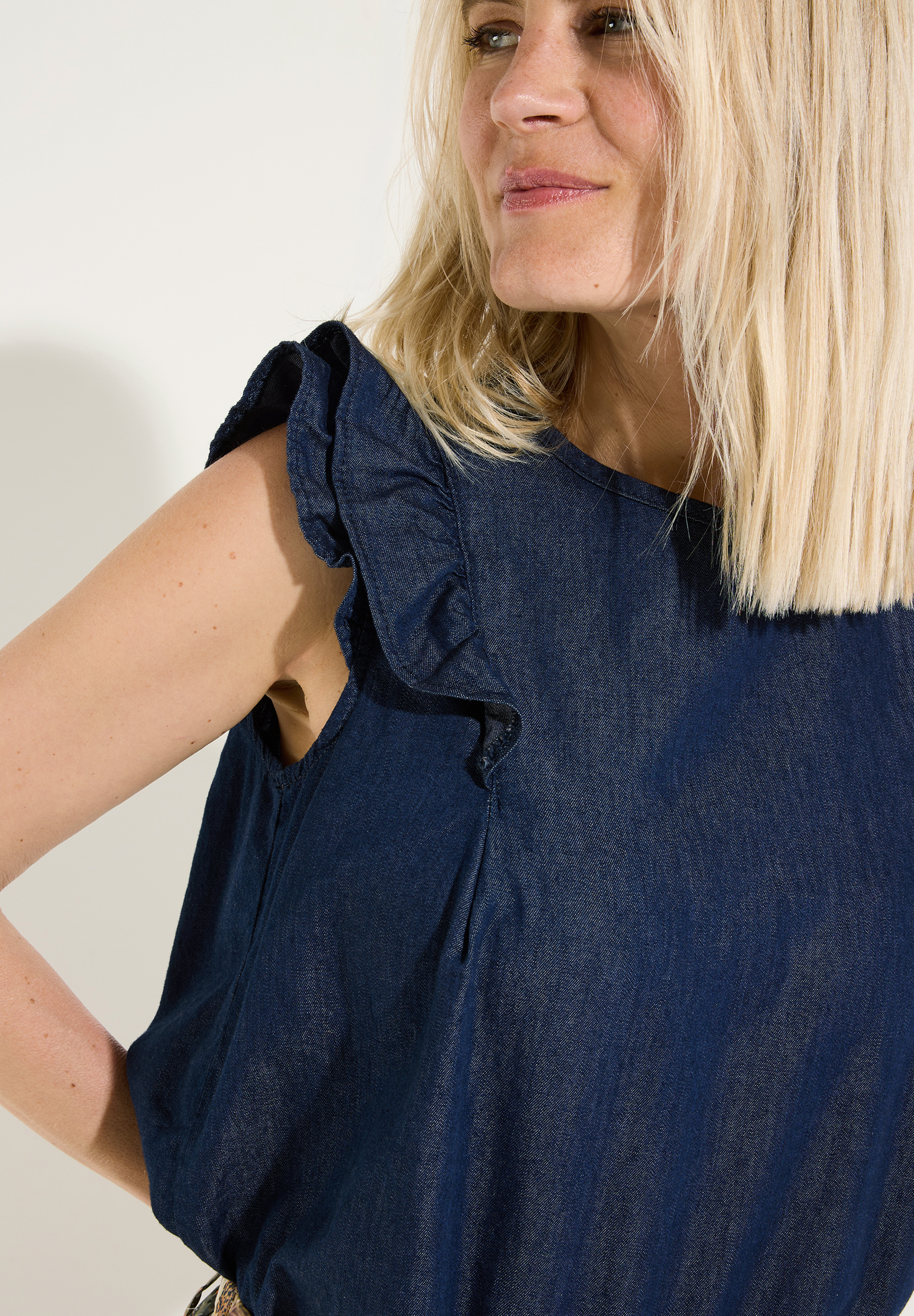 MORE & MORE Damenbluse aus Denim mit Volantärmeln, locker fallend und hautfreundlich, im Profil getragen. MORE & MORE Damenbluse aus Denim mit Volantärmeln, locker fallend und hautfreundlich, im Profil getragen.