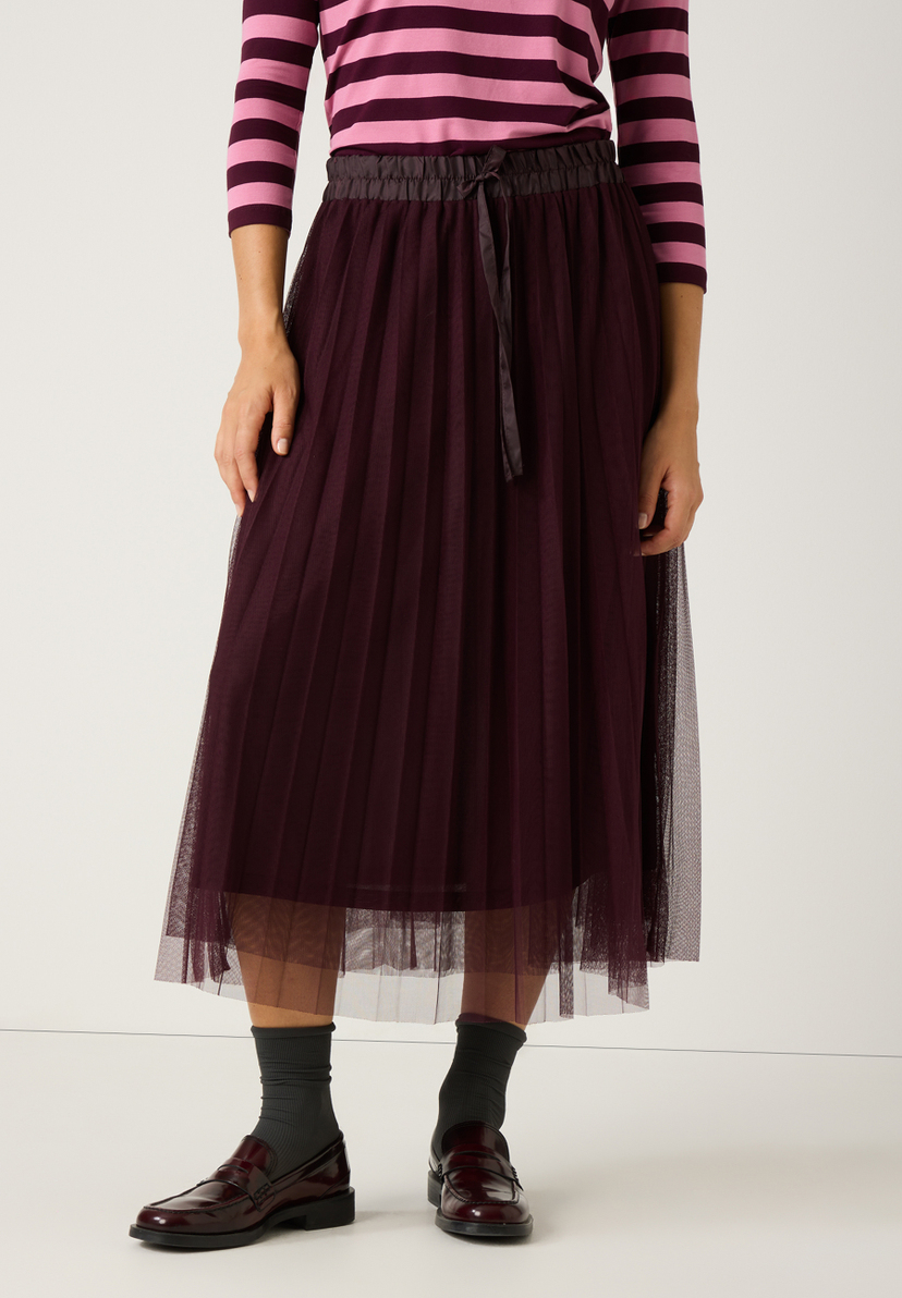 Ein elastischer MORE & MORE Rock mit Mesh-Material in dunklem Lila, kombiniert mit einem gestreiften Oberteil. Ein elastischer MORE & MORE Rock mit Mesh-Material in dunklem Lila, kombiniert mit einem gestreiften Oberteil.