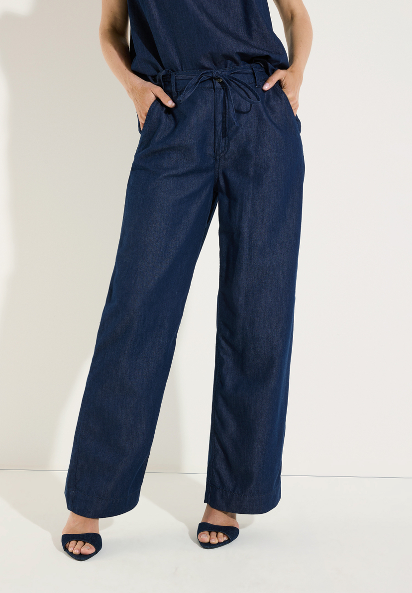 MORE & MORE Jeans: eine Person trägt eine dunkle Jeans mit weitem Bein und Kordelzug auf weißem Hintergrund. MORE & MORE Jeans: eine Person trägt eine dunkle Jeans mit weitem Bein und Kordelzug auf weißem Hintergrund.