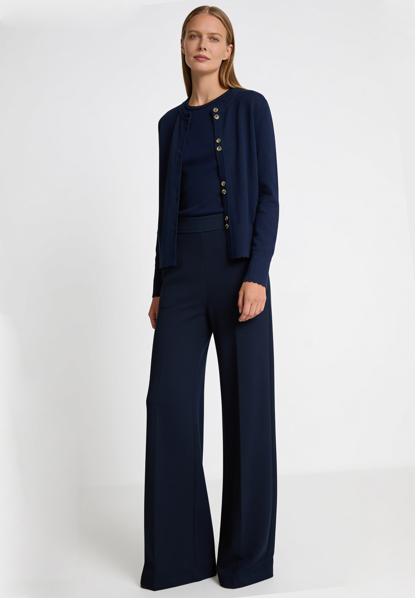 AI generated - MORE & MORE Feinstrick-Oberteil: Eine Frau trägt eine dunkelblaue Strickjacke mit Wellenkanten und passendem Top und Hose.
