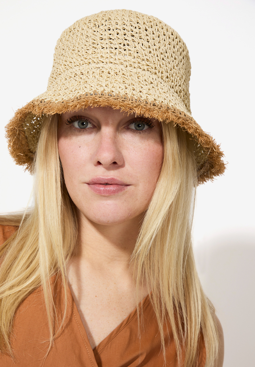 Nahaufnahme einer Frau mit blonden Haaren und einem MORE & MORE Hut aus Stroh. Nahaufnahme einer Frau mit blonden Haaren und einem MORE & MORE Hut aus Stroh.