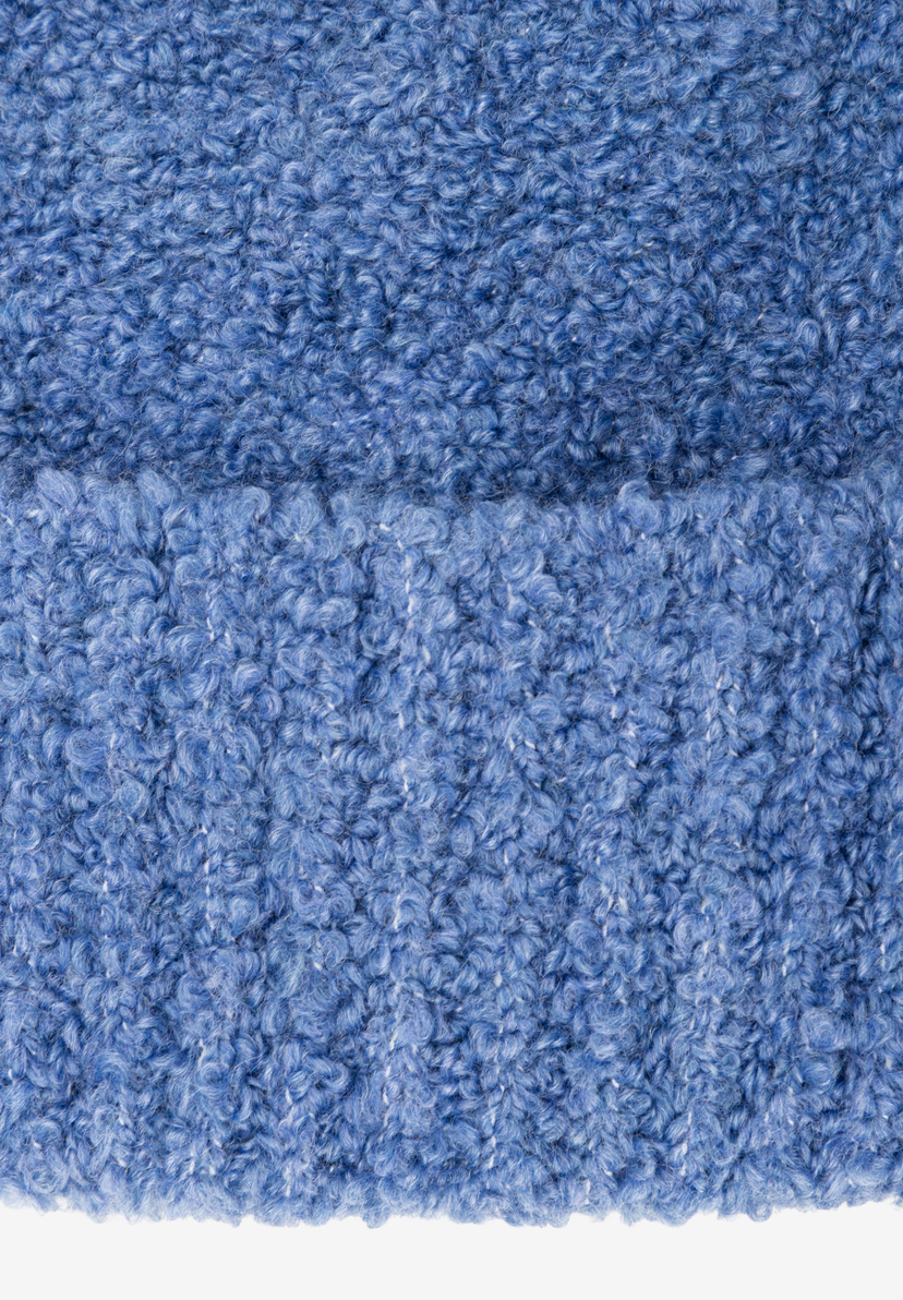 Nahaufnahme einer blauen MORE & MORE Mütze mit lockiger Textur. Weiches, warmes Accessoire für kalte Tage. Nahaufnahme einer blauen MORE & MORE Mütze mit lockiger Textur. Weiches, warmes Accessoire für kalte Tage.