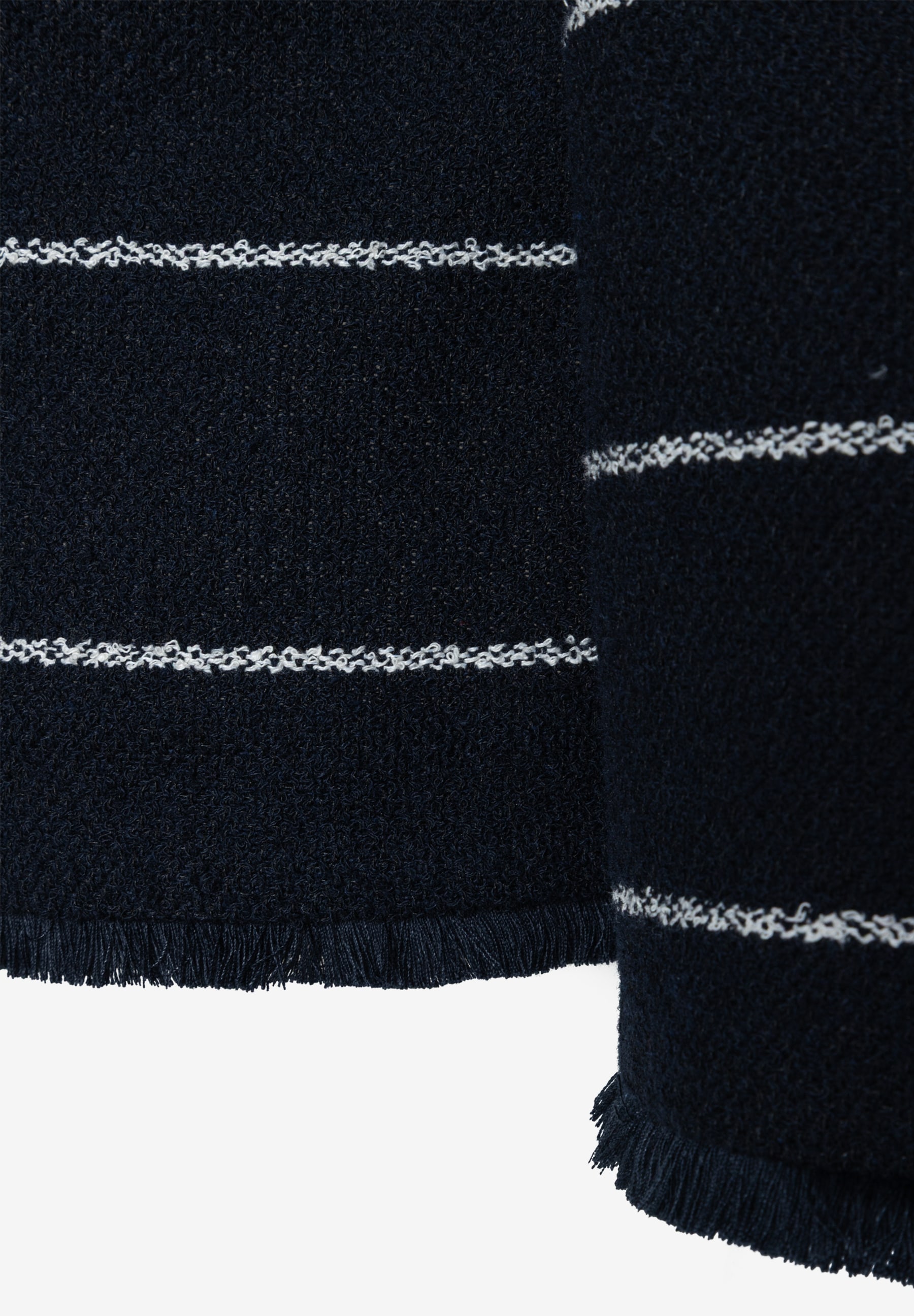 Nahaufnahme eines MORE & MORE Blazers aus Bouclé mit Fransen und weißen Streifen. Nahaufnahme eines MORE & MORE Blazers aus Bouclé mit Fransen und weißen Streifen.