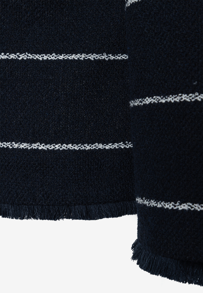 Nahaufnahme eines MORE & MORE Blazers aus Bouclé mit Fransen und weißen Streifen. Nahaufnahme eines MORE & MORE Blazers aus Bouclé mit Fransen und weißen Streifen.