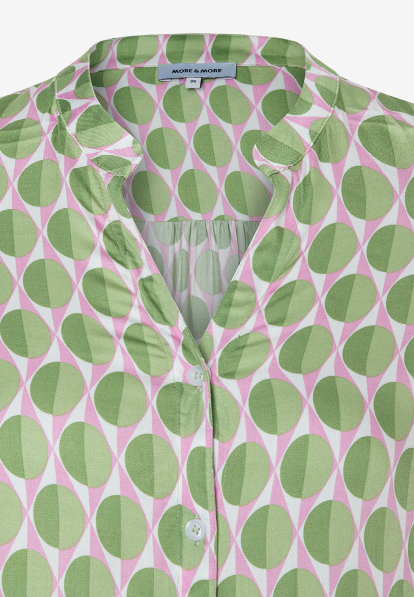 Detailansicht einer MORE & MORE Bluse mit grün-rosa Muster und Knopfleiste. Detailansicht einer MORE & MORE Bluse mit grün-rosa Muster und Knopfleiste.