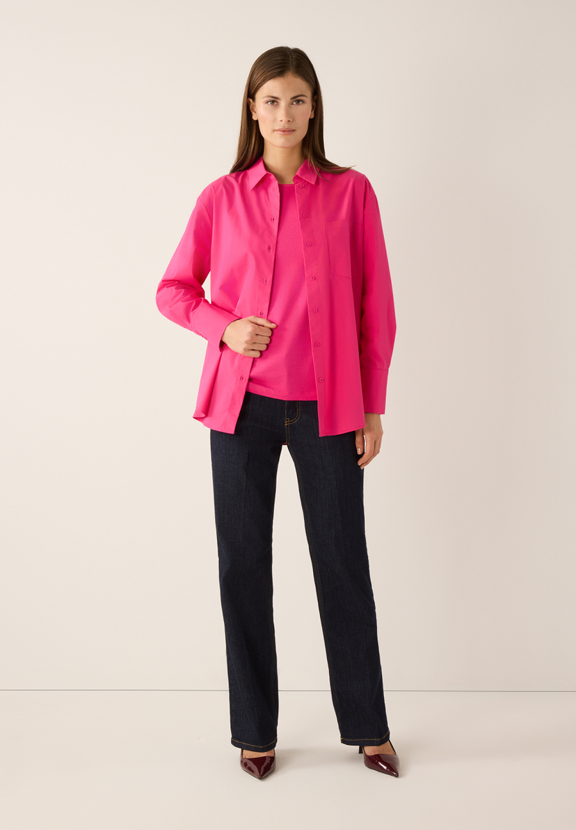 Eine Frau trägt ein pinkes Hemd und ein passendes T-Shirt von MORE & MORE, dazu Jeans und hochhackige Schuhe. Eine Frau trägt ein pinkes Hemd und ein passendes T-Shirt von MORE & MORE, dazu Jeans und hochhackige Schuhe.