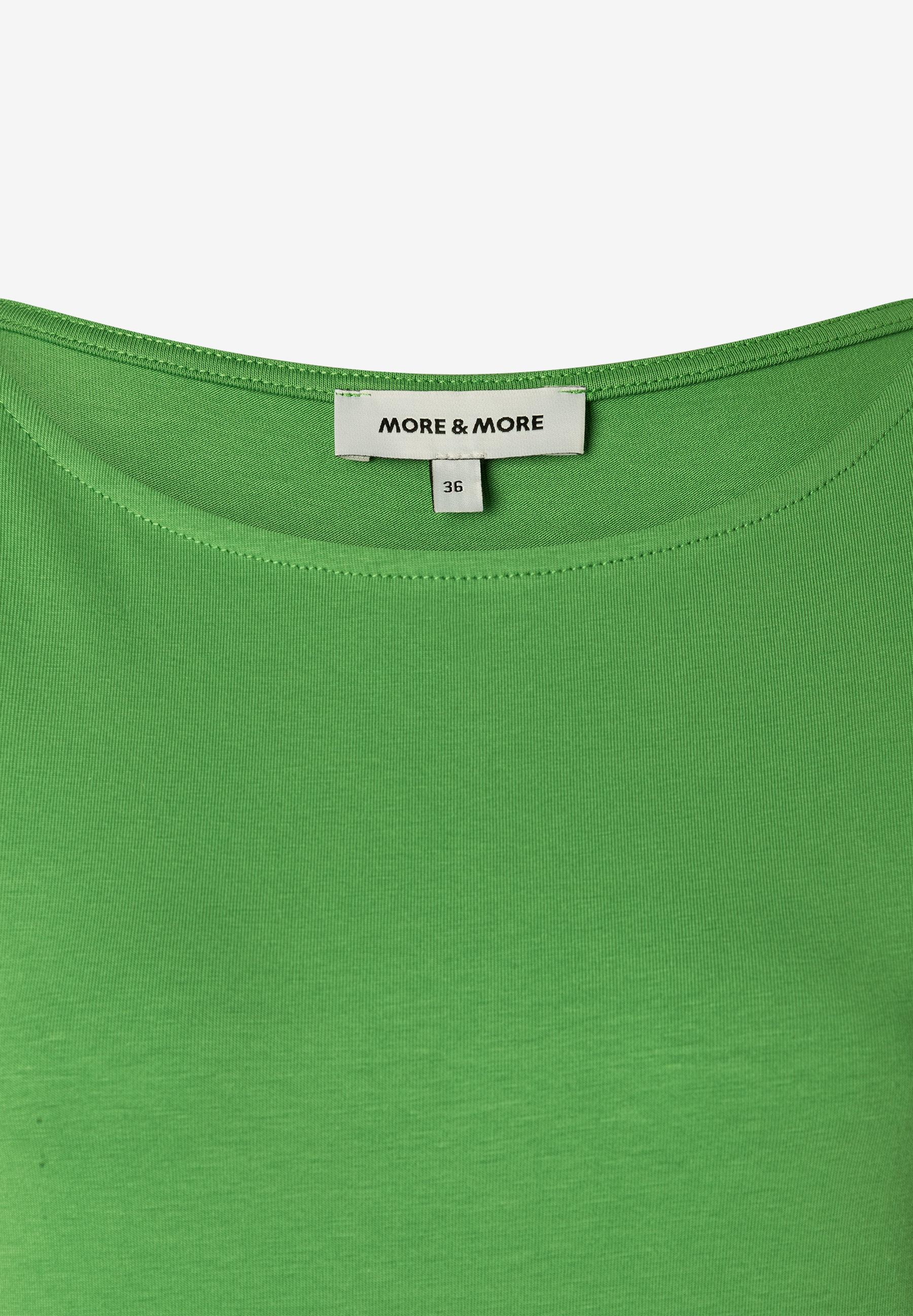 Nahaufnahme eines grünen MORE & MORE-Tops mit Jersey-Material und Größenetikett. Nahaufnahme eines grünen MORE & MORE-Tops mit Jersey-Material und Größenetikett.