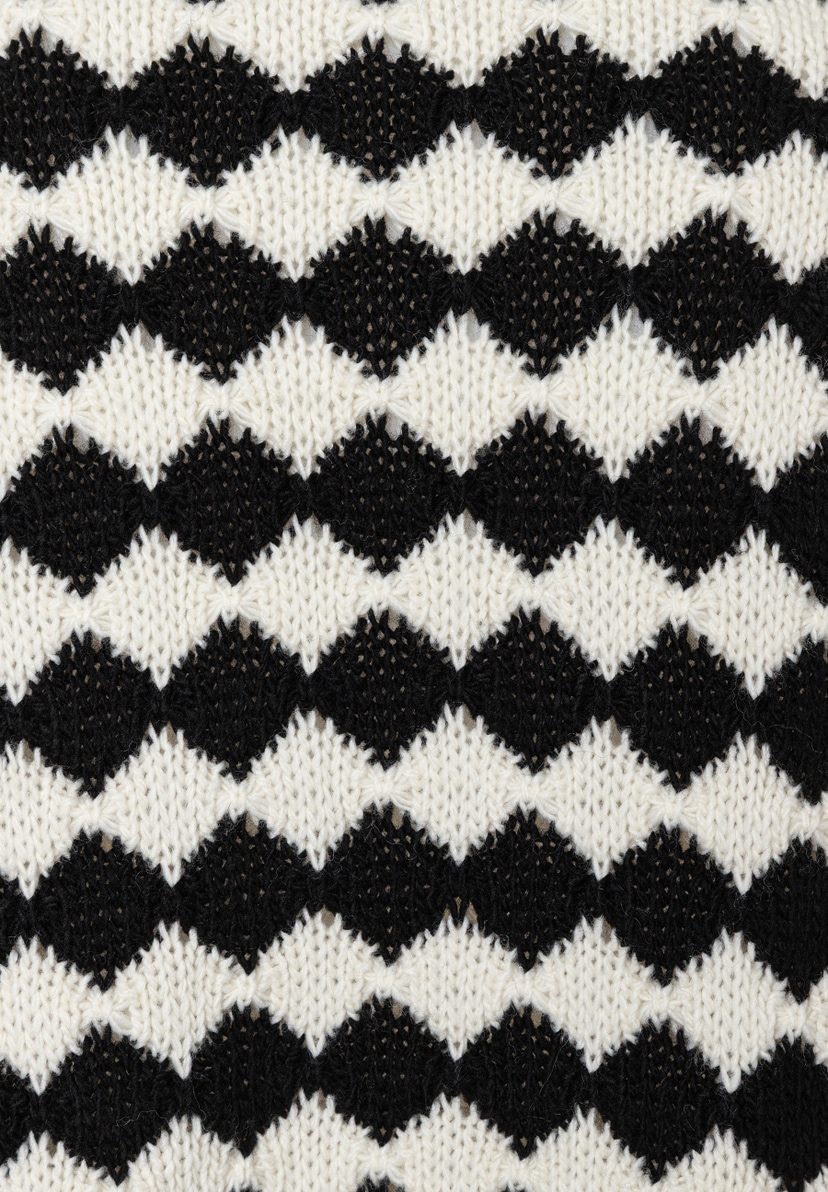 Detailaufnahme von MORE & MORE Strickware in Schwarz und Weiß mit Rautenmuster. Detailaufnahme von MORE & MORE Strickware in Schwarz und Weiß mit Rautenmuster.