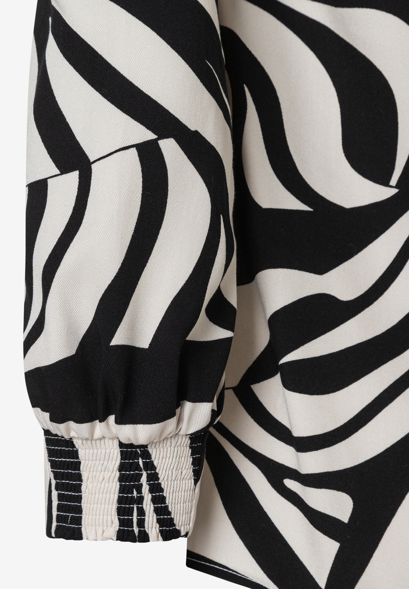 Ärmel einer MORE & MORE Bluse mit abstraktem Zebra-Muster und gerafftem Bündchen. Ärmel einer MORE & MORE Bluse mit abstraktem Zebra-Muster und gerafftem Bündchen.